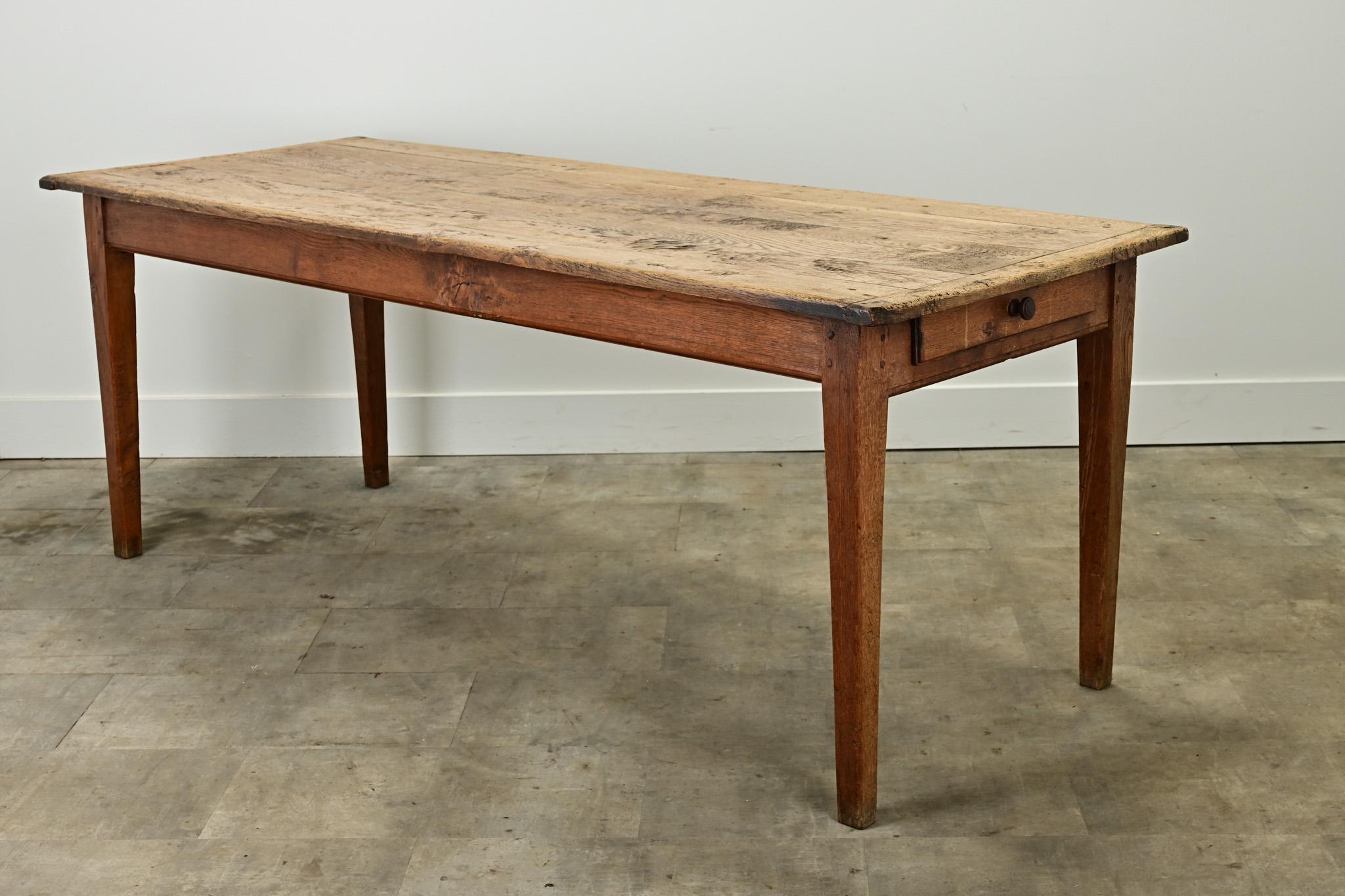 This rustic dining table from France is the perfect dining table to seat  6- 8 guests. The simple plank top has many layers of patina with breadboard ends over a study base. You’ll find one drawer on one side of the apron over squared and tapered