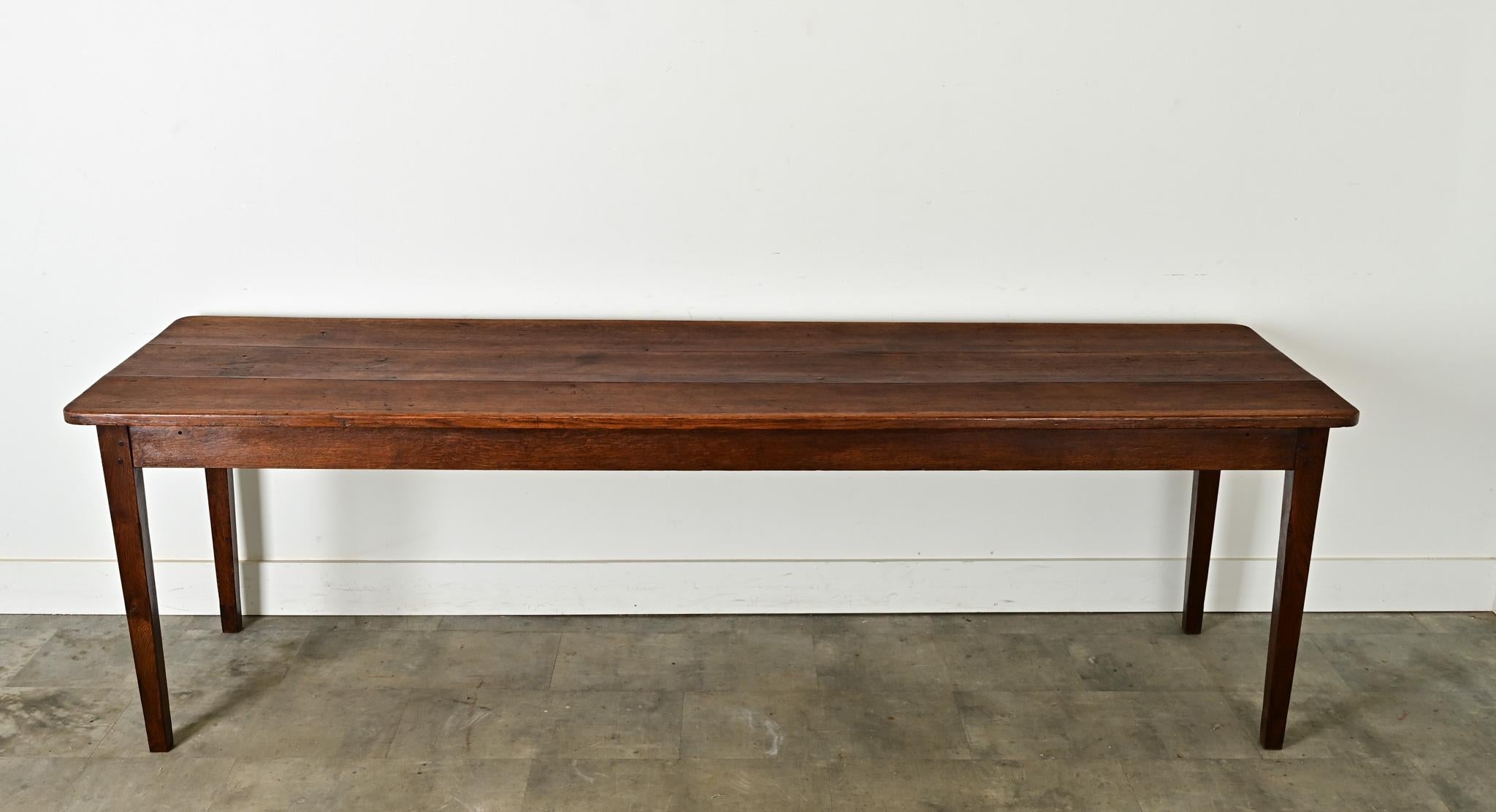 A narrow French antique farmhouse table–for dining or working–from Burgundy, circa 1880. The table is delightfully patinated from its former life as a work table at a farm or vineyard, a storied history that will be the perfect background and