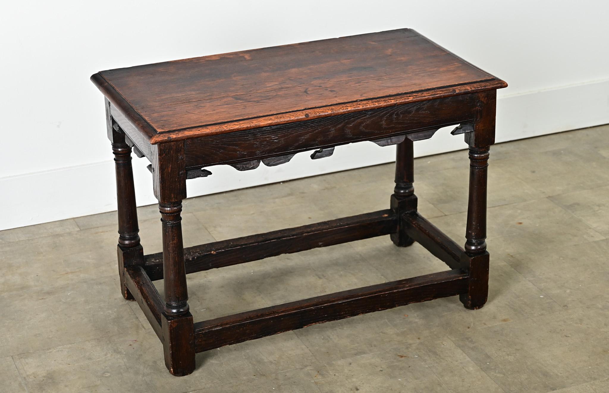 An exceptional, solid oak table from France, 19th century, it is of ideal proportions to function as a side table, a bench, or stool in any number of settings. This example offers a rectangular top of a single plank with overhanging edges on three