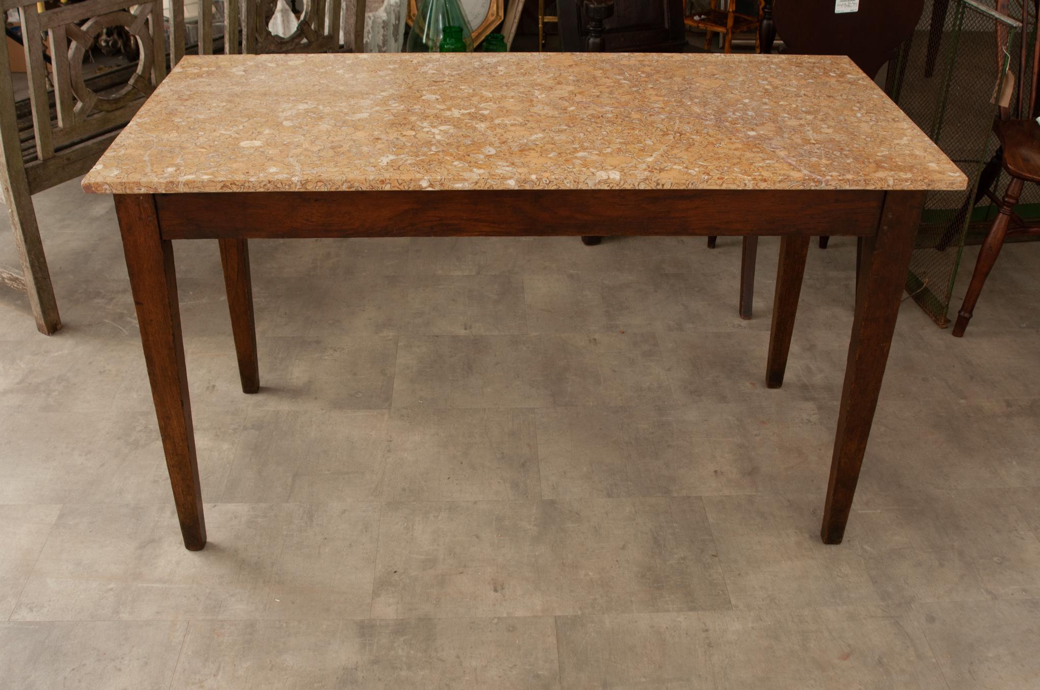 A 19th century oak cafe table crafted in France circa 1870 with a fantastic patterned stone top over a richly patinated solid oak base with tapered square legs. Its spare design makes it very versatile. This piece would work beautifully in a kitchen