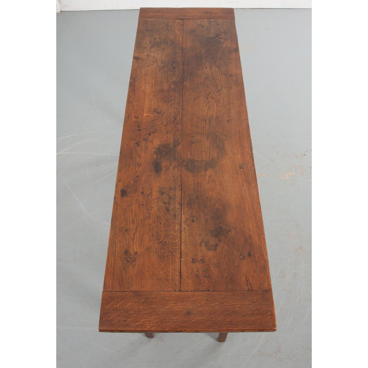 This provincial server is made of solid oak from France, circa 1870. The top has a great patina and sits atop a single drawered apron fixed with a turned pull. Constructed with slender legs and a narrow whole, this table would be perfect in an