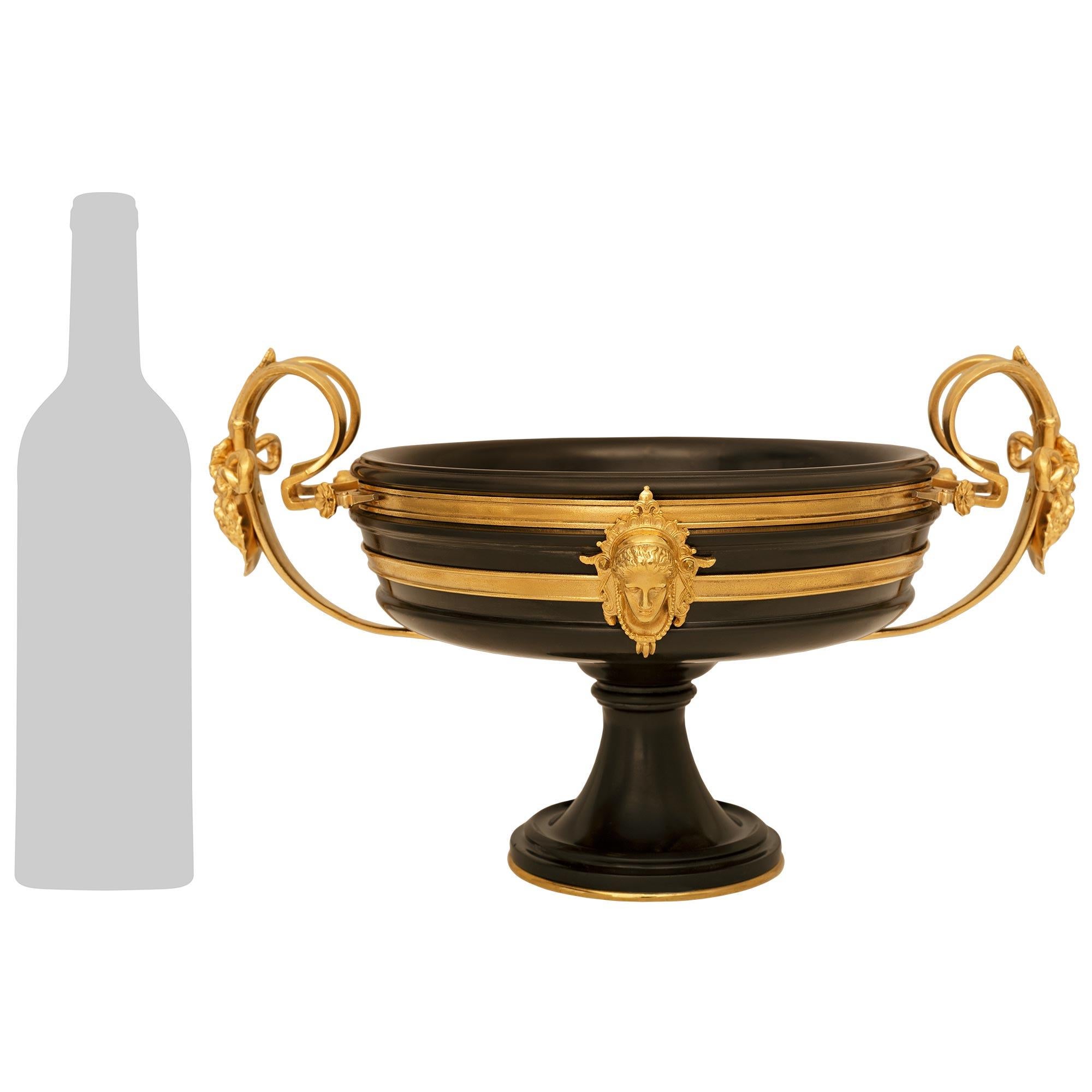 Un bel centrotavola francese del XIX secolo in stile Luigi XVI in ormolu e marmo nero belga, firmato F. Barbedienne. Questo splendido centrotazza è sollevato su una base circolare in Ormolu sotto il supporto in marmo belga nero a fasce screziate.