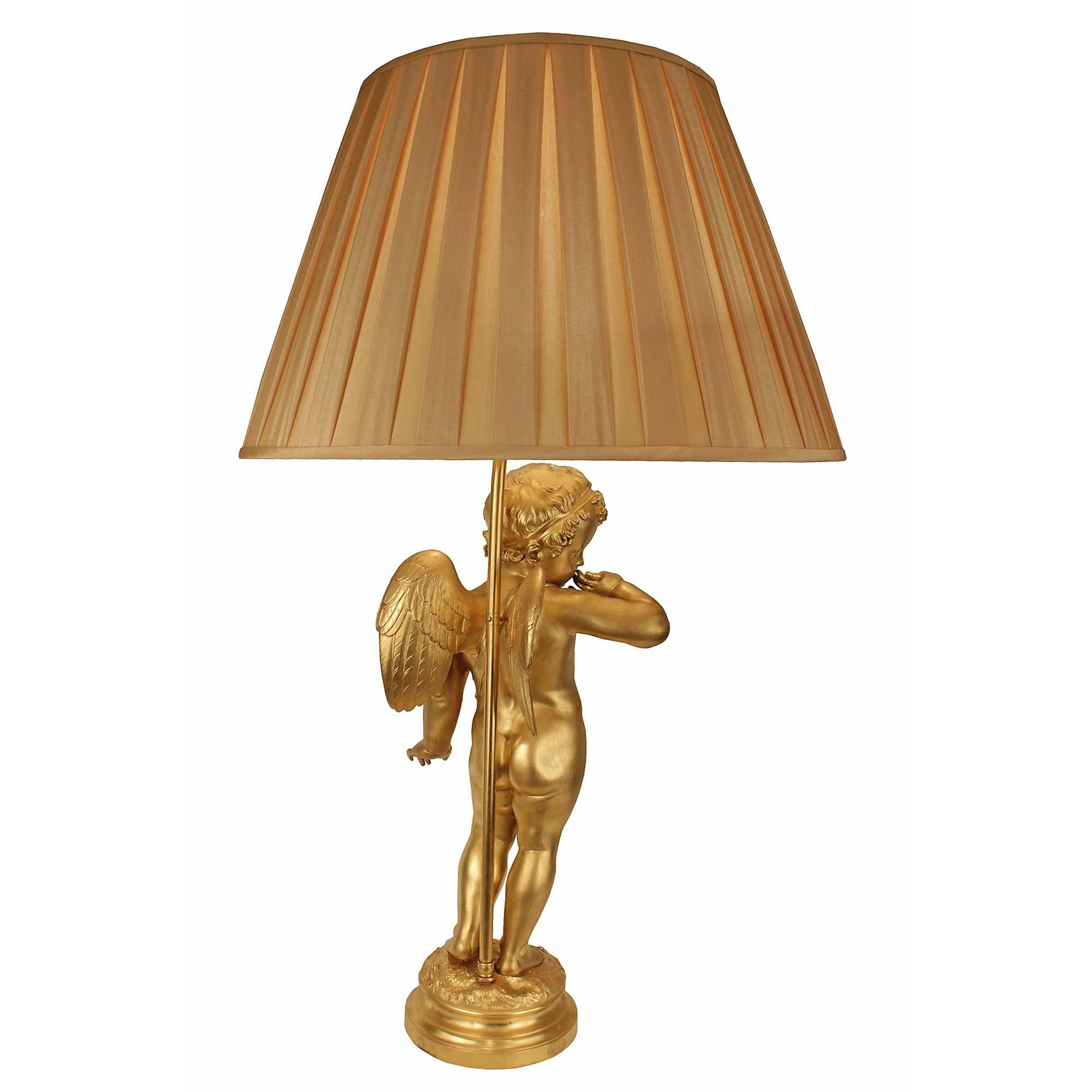 A stunning French 19th century ormolu cherub mounted in to a lamp, after a sculpture by Pigalle . The lamp is raised by a circular ormolu mottled base where the winged cherub stands on etched grass where the signature is displayed. The richly chased