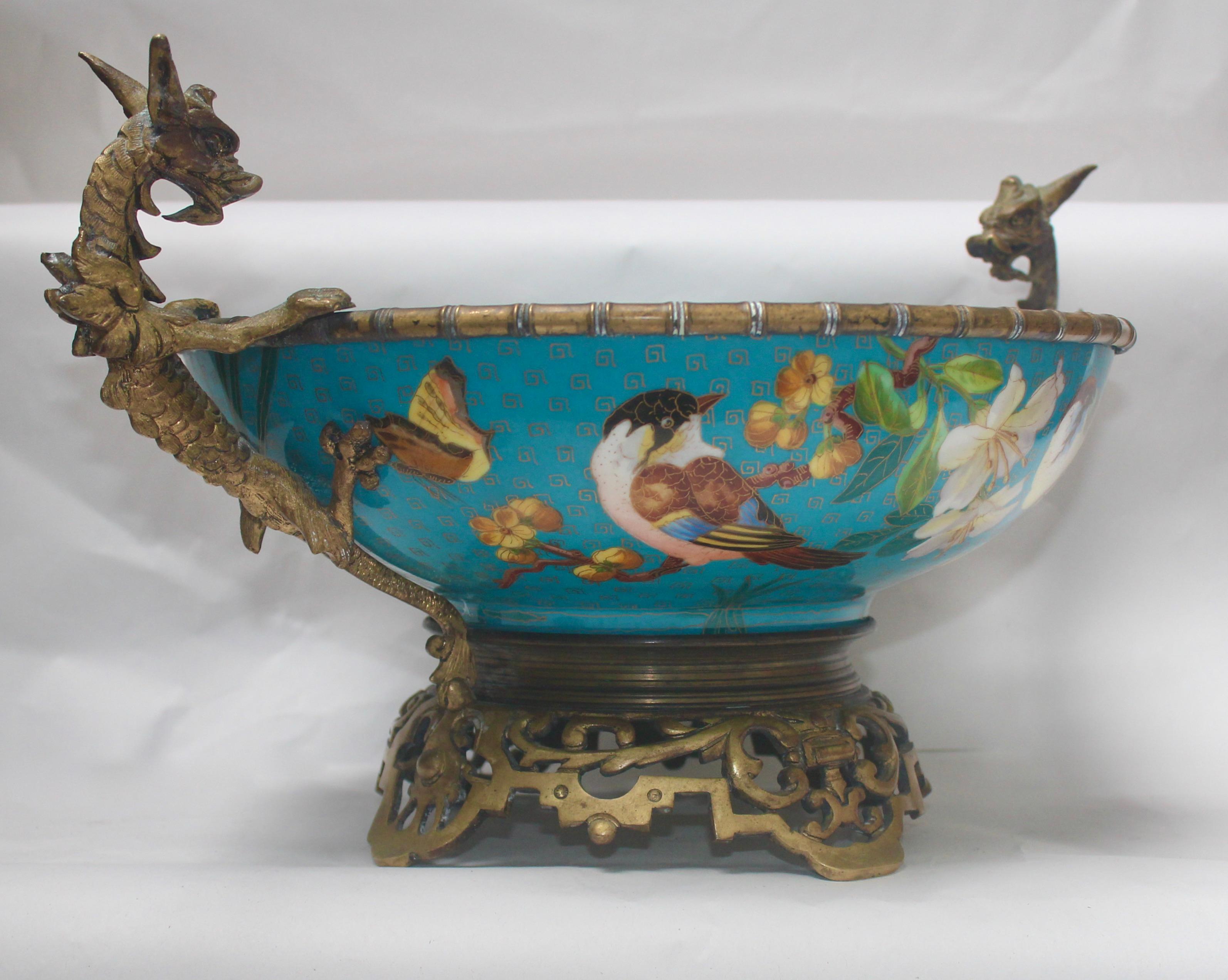 A circular French 19th century ormolu-mounted and polychromed porcelain centerpiece.
Designed and inspired in the Chinese taste with birds, butterflies, foliages and flowers on a blue-ground simulating Chinese cloisonné enamel.
The mounts with two