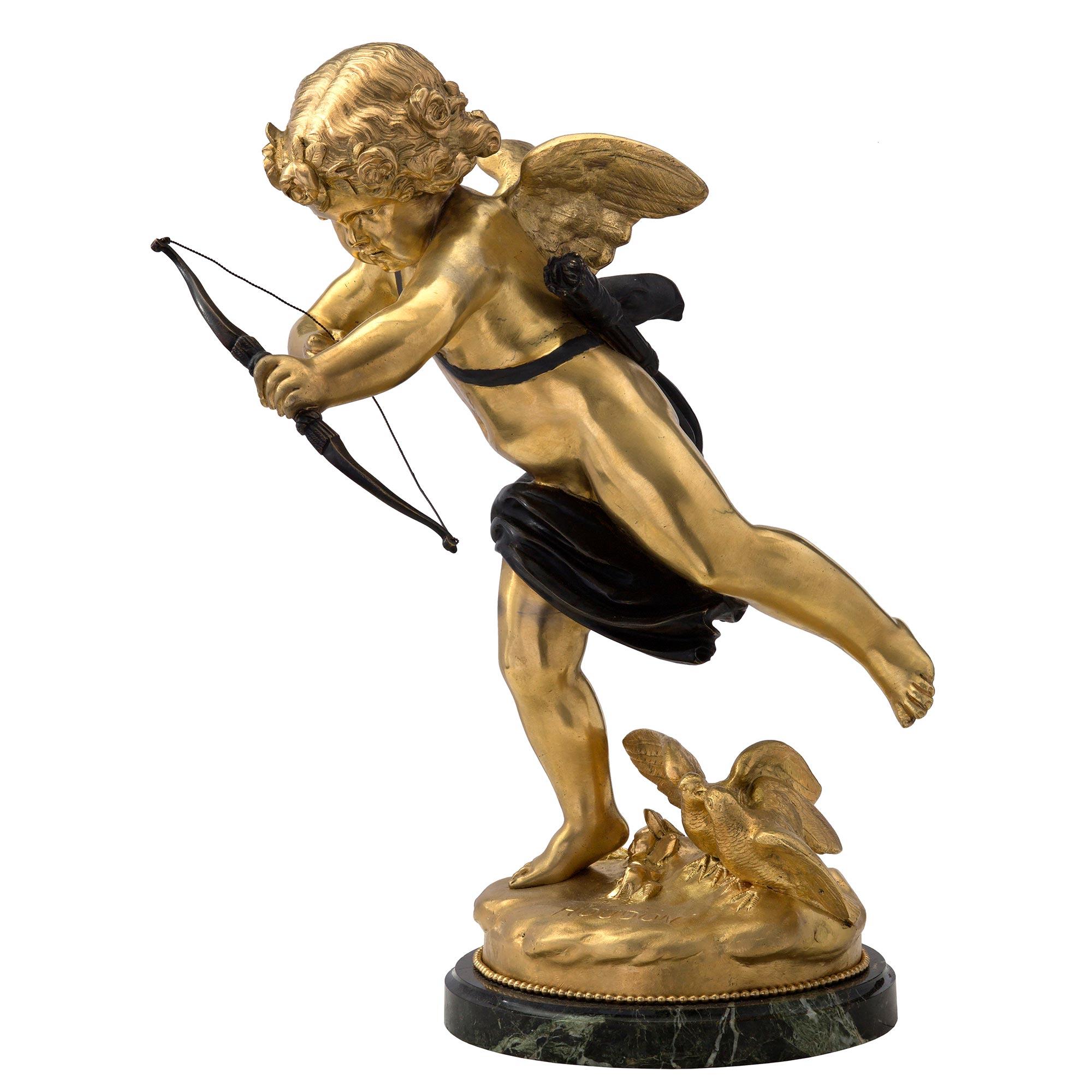 A most charming and high quality French 19th century ormolu, patinated bronze and marble statue signed HOUDON. The statue is raised by a circular mottled Vert Antique marble base with a decorative ormolu beaded band. The wonderfully executed statue