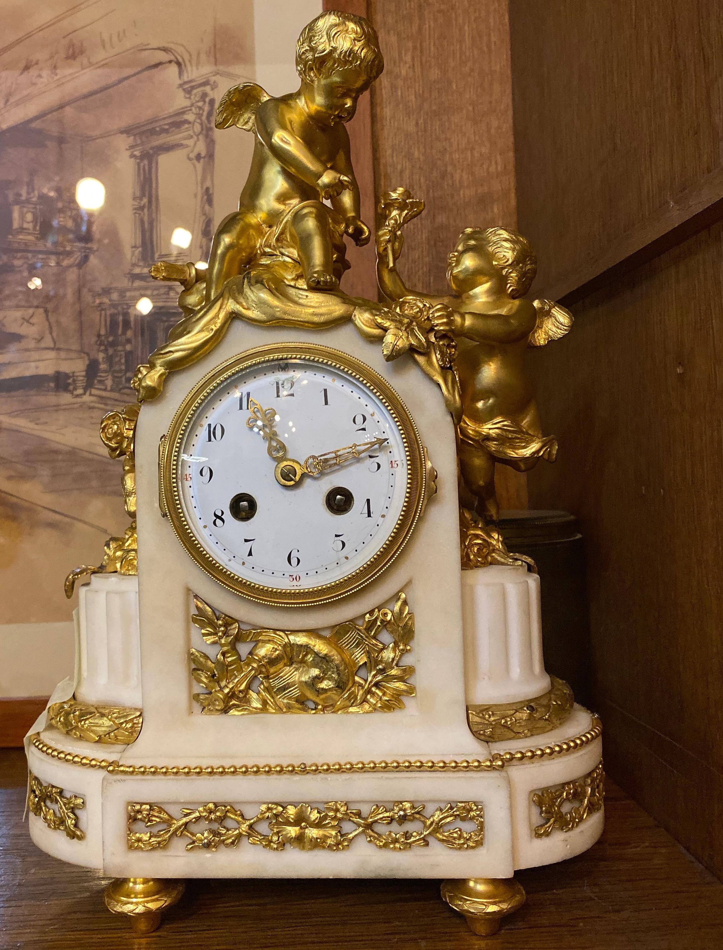 Delicious French white marble ormolu mantel clock resting on four turned feet supporting an oval marble base with raised garland decoration. Two gracious cherubs are seated upon the ormolu draped base.
Striking every half hour and hour.
Perfect