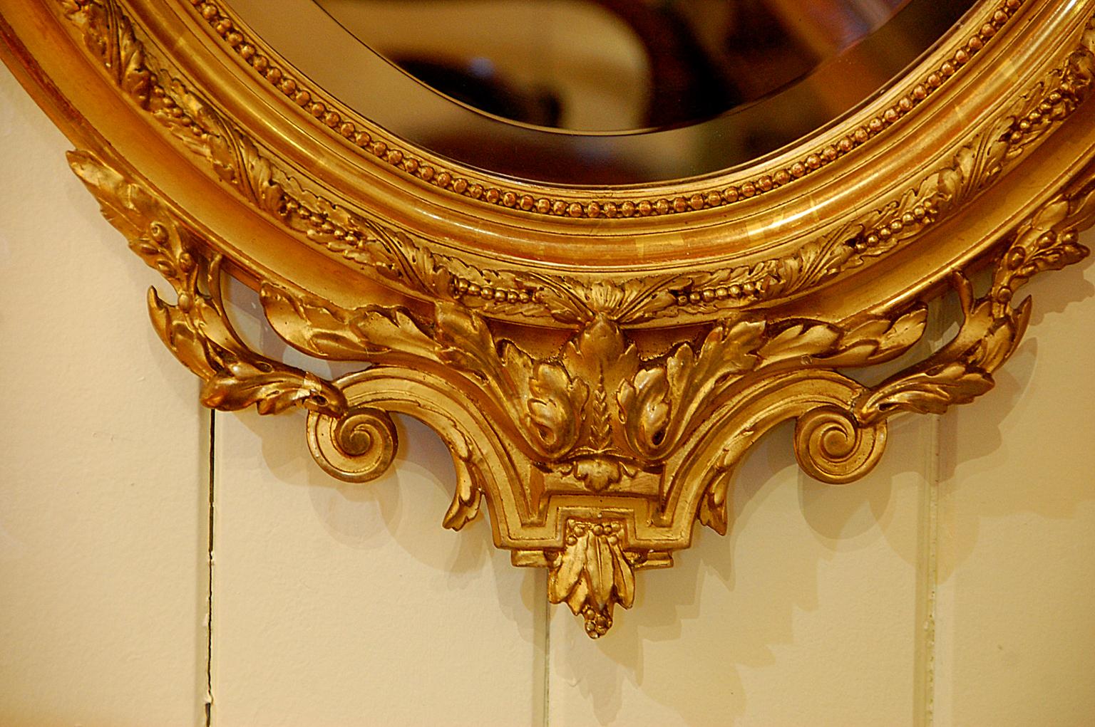 Français Miroir ovale français du 19ème siècle sculpté à motifs floraux en feuilles d'or, flambeau, carquois en vente