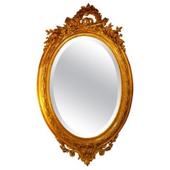 Miroir ovale français du 19ème siècle sculpté à motifs floraux en feuilles d'or, flambeau, carquois