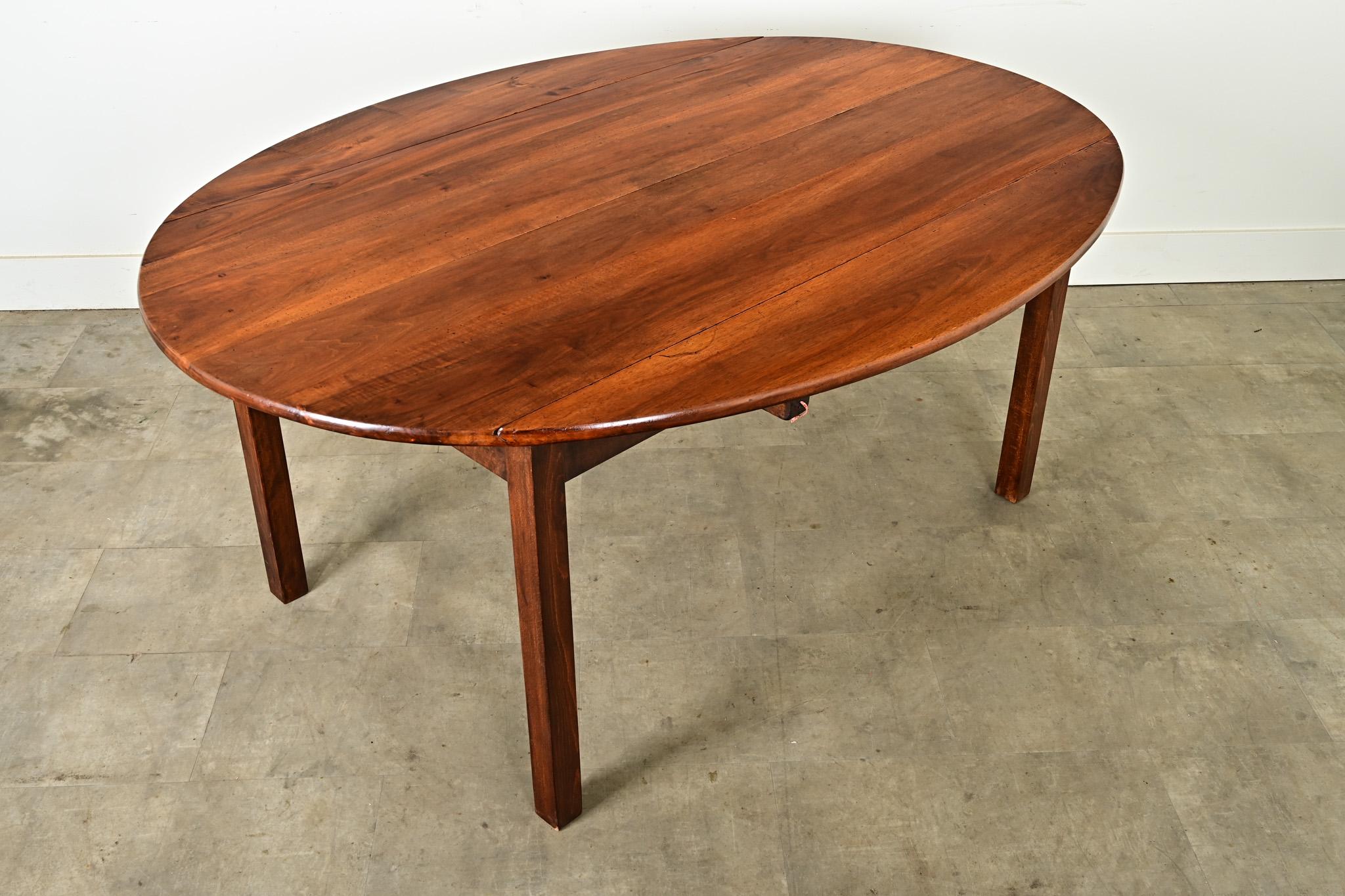 Le noyer chaud et merveilleusement patiné enveloppe cette magnifique table de salle à manger ovale à feuilles tombantes datant du 19ème siècle en France. Avec les feuilles relevées, la table est grande et idéale pour les repas. C'est l'endroit idéal