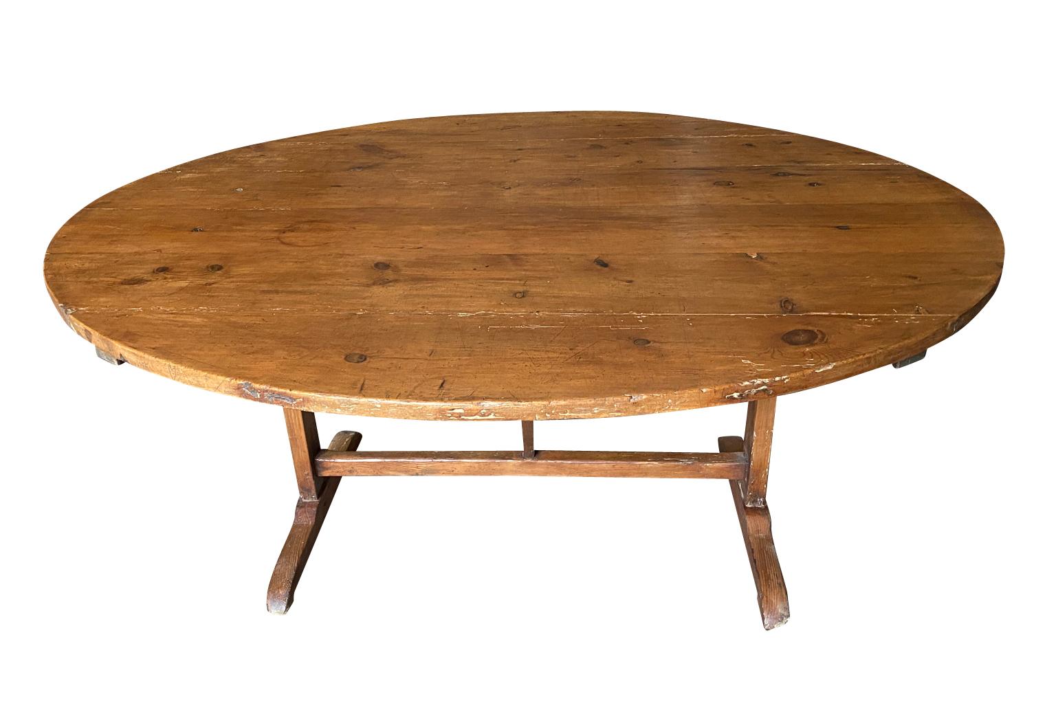 A very handsome 19th century oval shaped Wine Tasting Table - Table Vigneron - from the Provence region of France.  Beautifully constructed from handsomely stained pine with a tilting top.  Perfect as a relaxed dining table.  Wonderful patina.