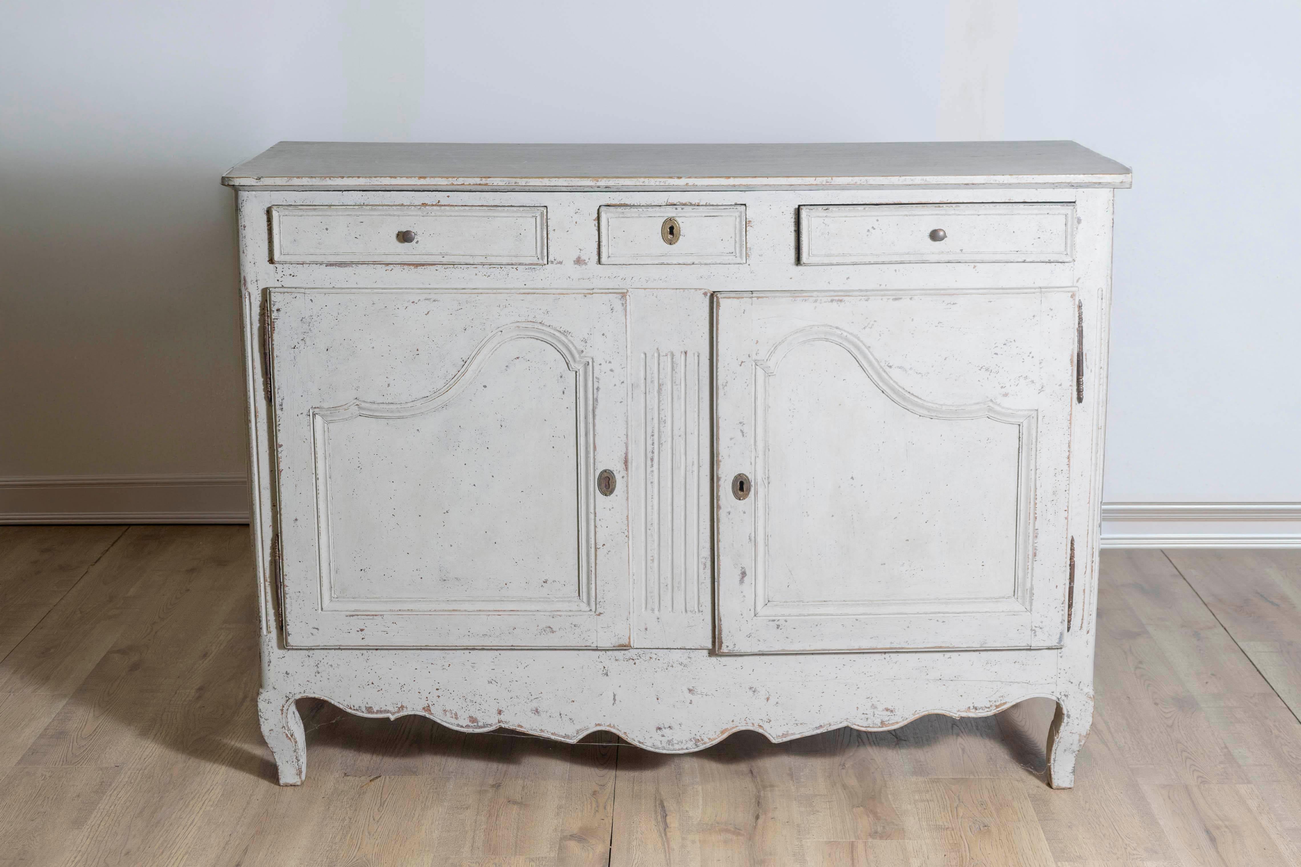 Un buffet francese in legno dipinto risalente al XIX secolo, con tre cassetti, due ante, accenti scanalati e finitura affilata. Creato in Francia nel XIX secolo, questo buffet dipinto presenta un piano rettangolare con angoli arrotondati nella parte