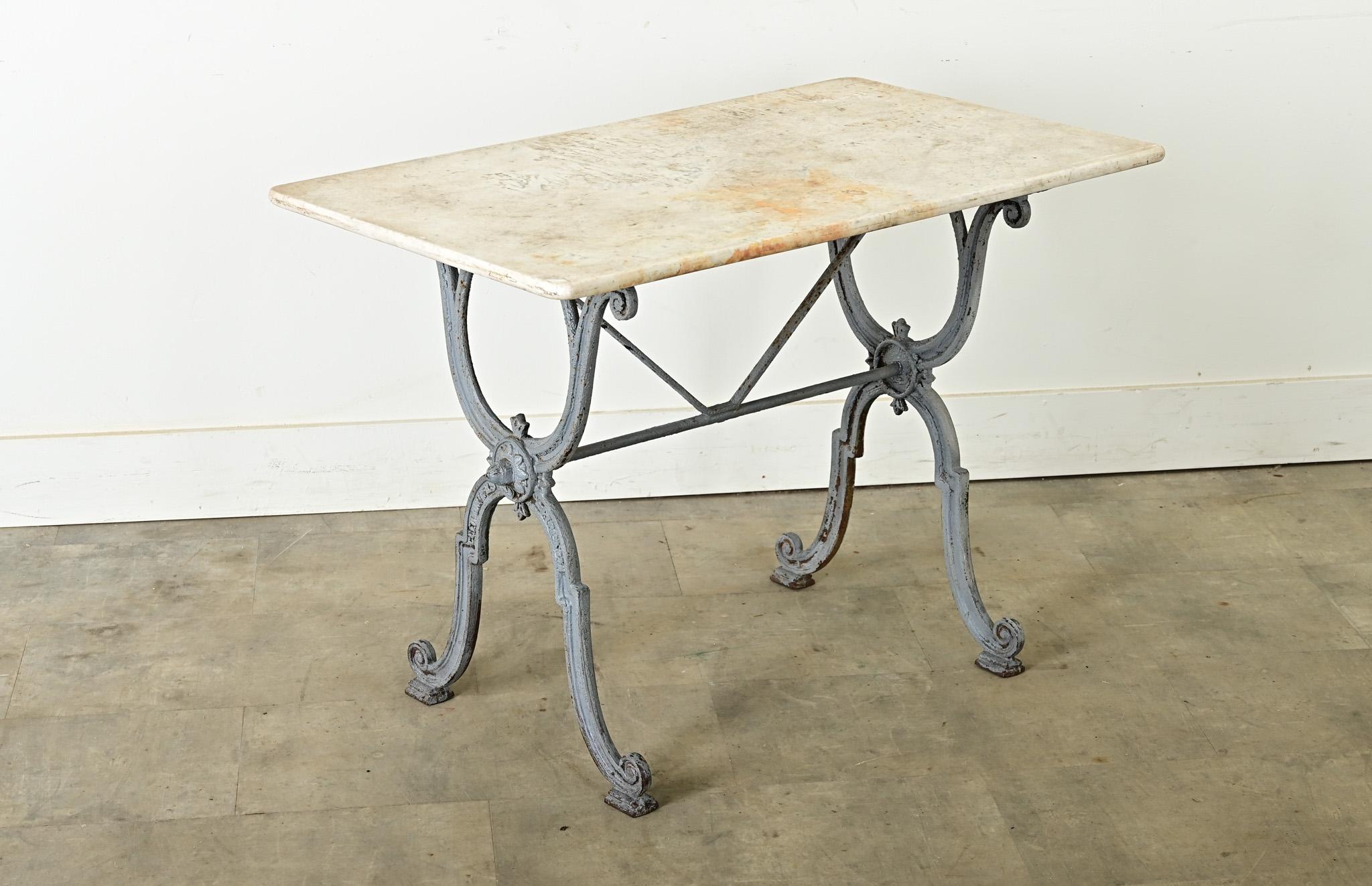 Table de bistrot française du début du 20e siècle (vers 1900) avec des détails d'époque Beaux Arts dans la base en fonte peinte en bleu-gris. Le plateau de marbre blanc présente une surface bien patinée, gravée et nuancée par plus d'un siècle