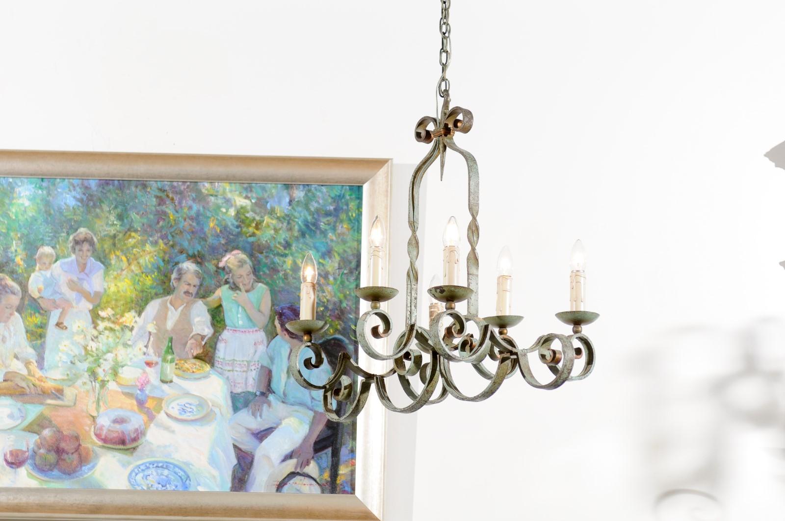 A French painted iron six-light chandelier from the 19th century, with scrolling arms and twisted patterns. Born in France during the 19th century, this six-light chandelier features a perfect combination of scrolls, accented with a grey green