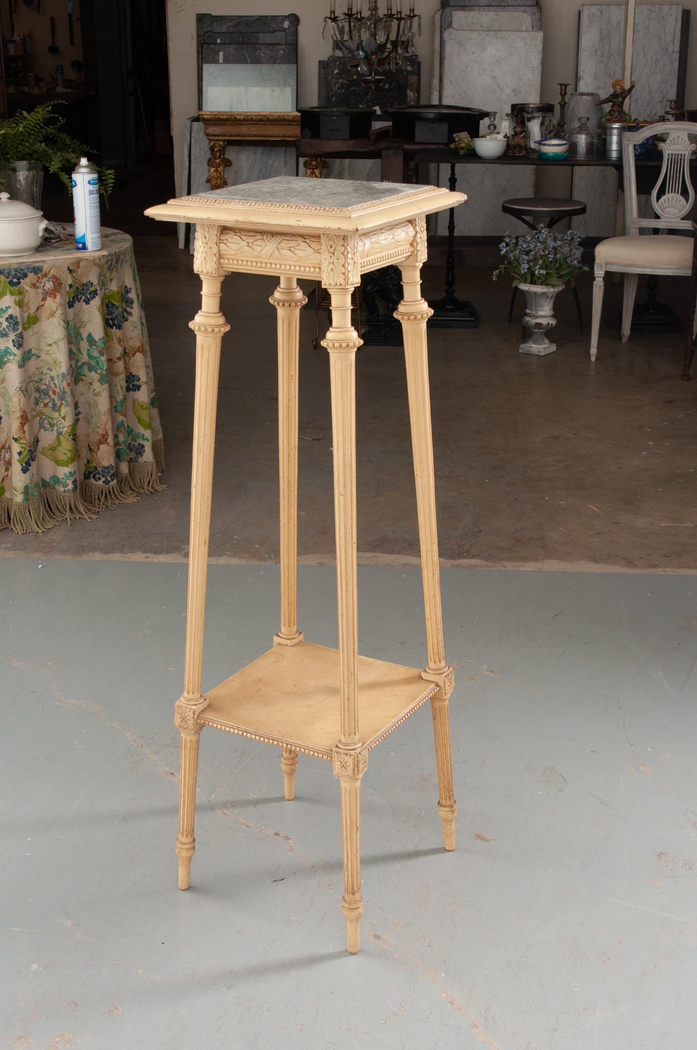 A sleek, painted pedestal table from 19th century France. The square top measures 10”x10” and features a unique green and white inset marble top. A perimeter of lambs tongue carving around the marble and leaf and berry motif add a touch of antique