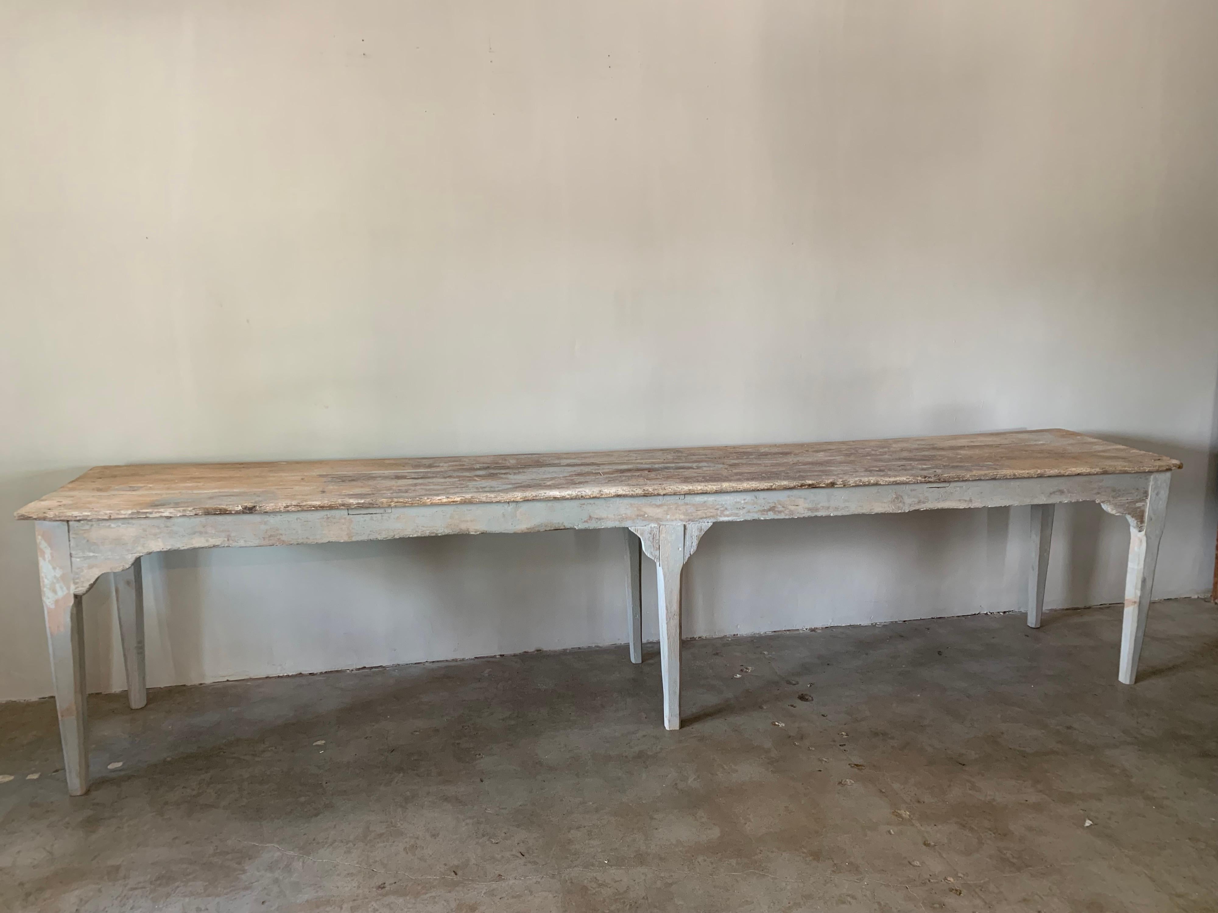 This is a long, beautiful, pale blue painted console table from France. It has wonderful character with old iron nails and original color underneath the later blue. 138” long x 25.88d x 31.25 tall