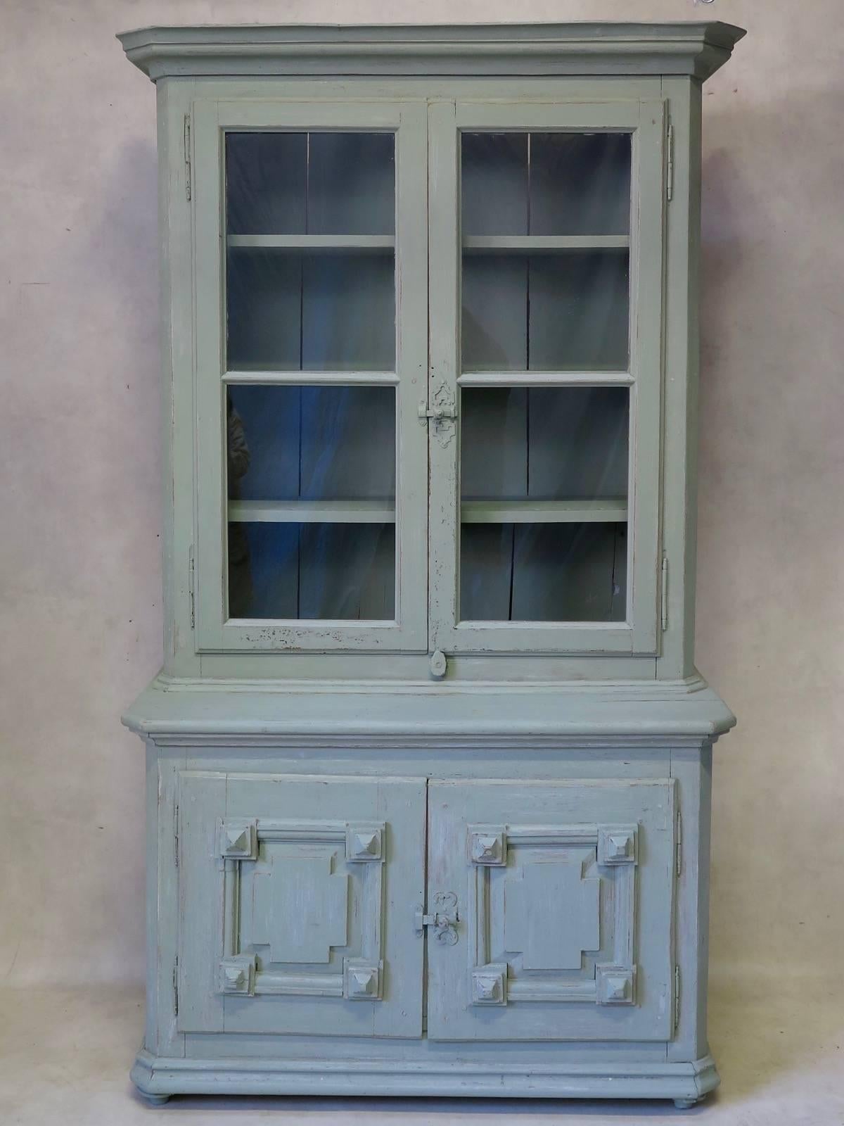 Charming, painted pinewood vitrine/display cabinet in two sections. The top section has glass panes and the lower section, two doors with diamond detail.