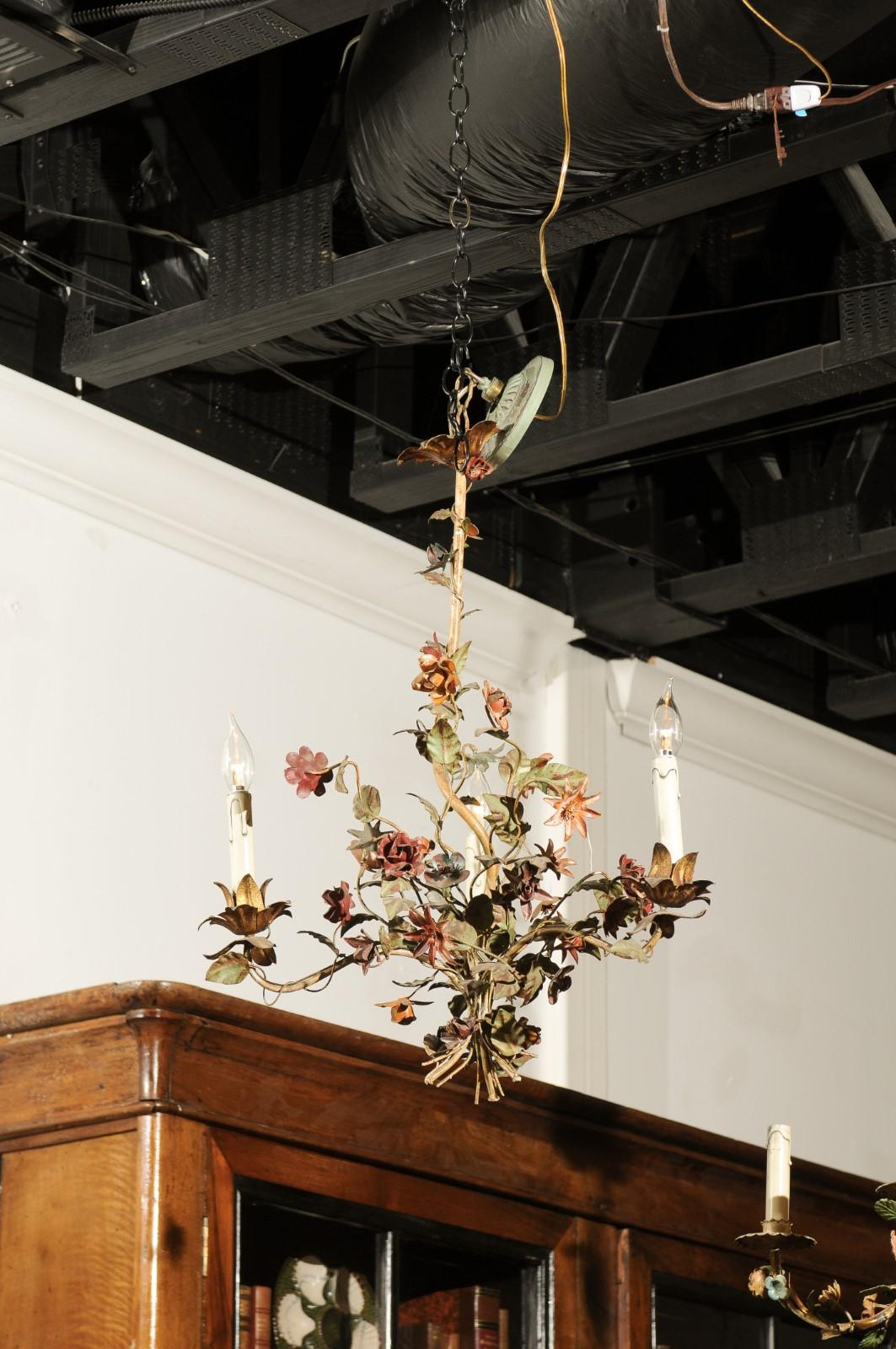 A French painted tôle three-light chandelier from the 19th century, with flower and vine motifs. Born in France during the politically dynamic 19th century, this charming three-light chandelier features a delicately scrolling armature wrapped with