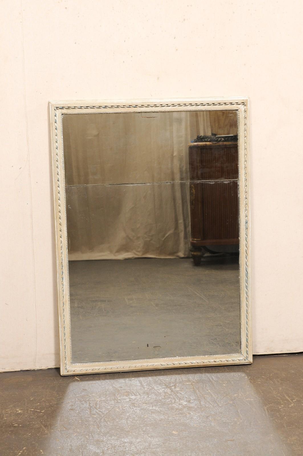 Specchio francese con cornice in legno dipinto e vetro originale in due parti, risalente al XIX secolo. Questo specchio da parete antico proveniente dalla Francia ha una forma rettangolare con un profilo lineare sul perimetro e accenti interni in