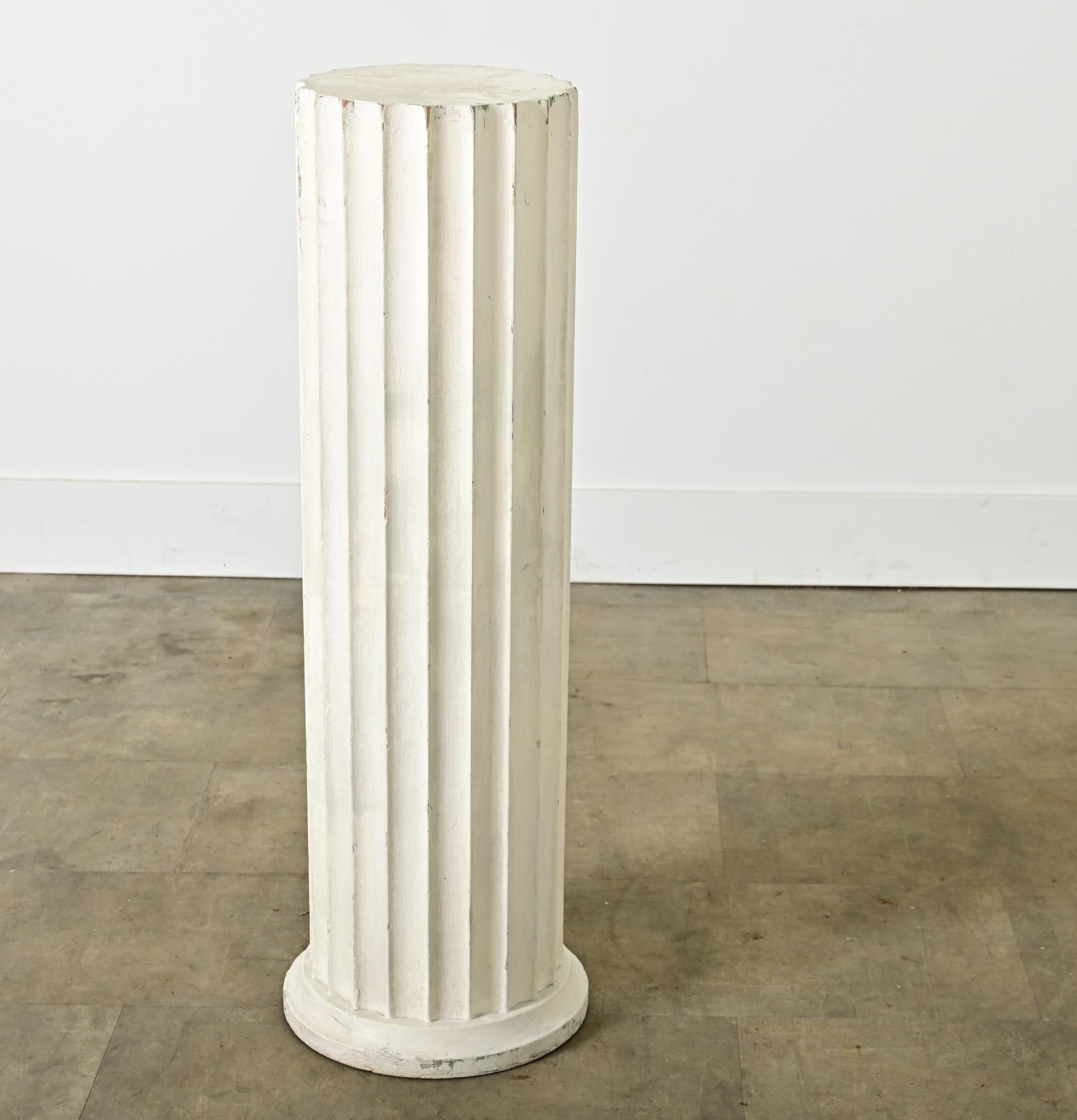 Colonne architecturale française d'une utilité infinie, cette déclaration néoclassique du 19e siècle est faite de bois sculpté, peint en blanc épais pour servir de piédestal à un vase, une urne ou une plante d'intérieur ornementale. La magnifique