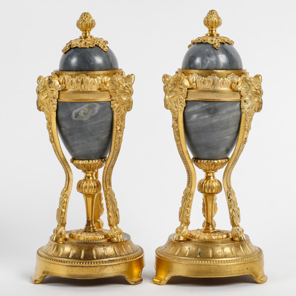 French 19th century Pair of Cassolettes Convertible in Candlesticks
Pair of cassolettes in Bleu Turquin marble and ormolu ornamentation.
Tripod base finished in sabots and decorated with ram's heads.
Lid with a seeded grip, reversible into a