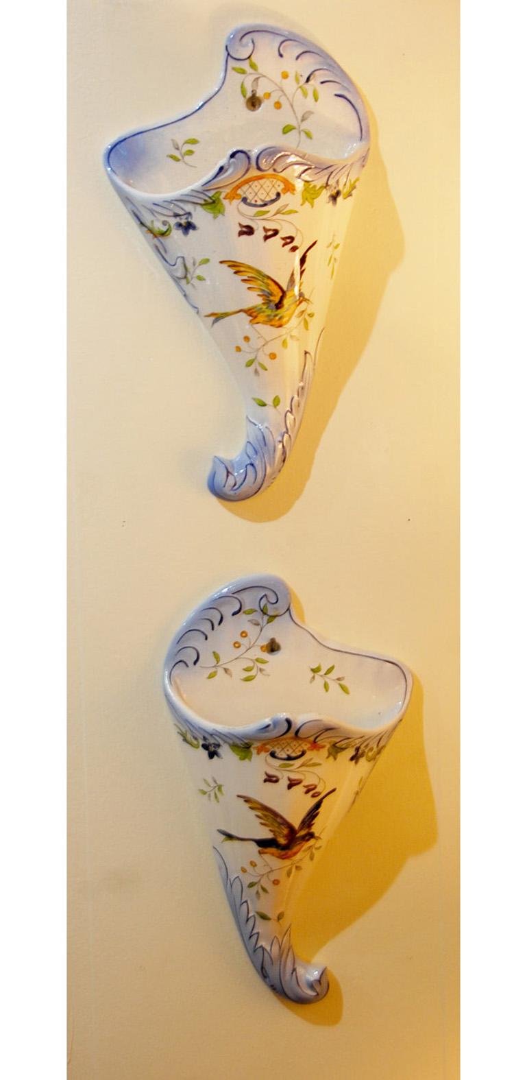 French 19th century Longchamp pair of faience hand painted wall pockets with bird and flower motifs, molded leaves to edges, cornucopia form. Crackleware glaze. Impressed mark: Longchamp Terre de Fer. Late 19th century.