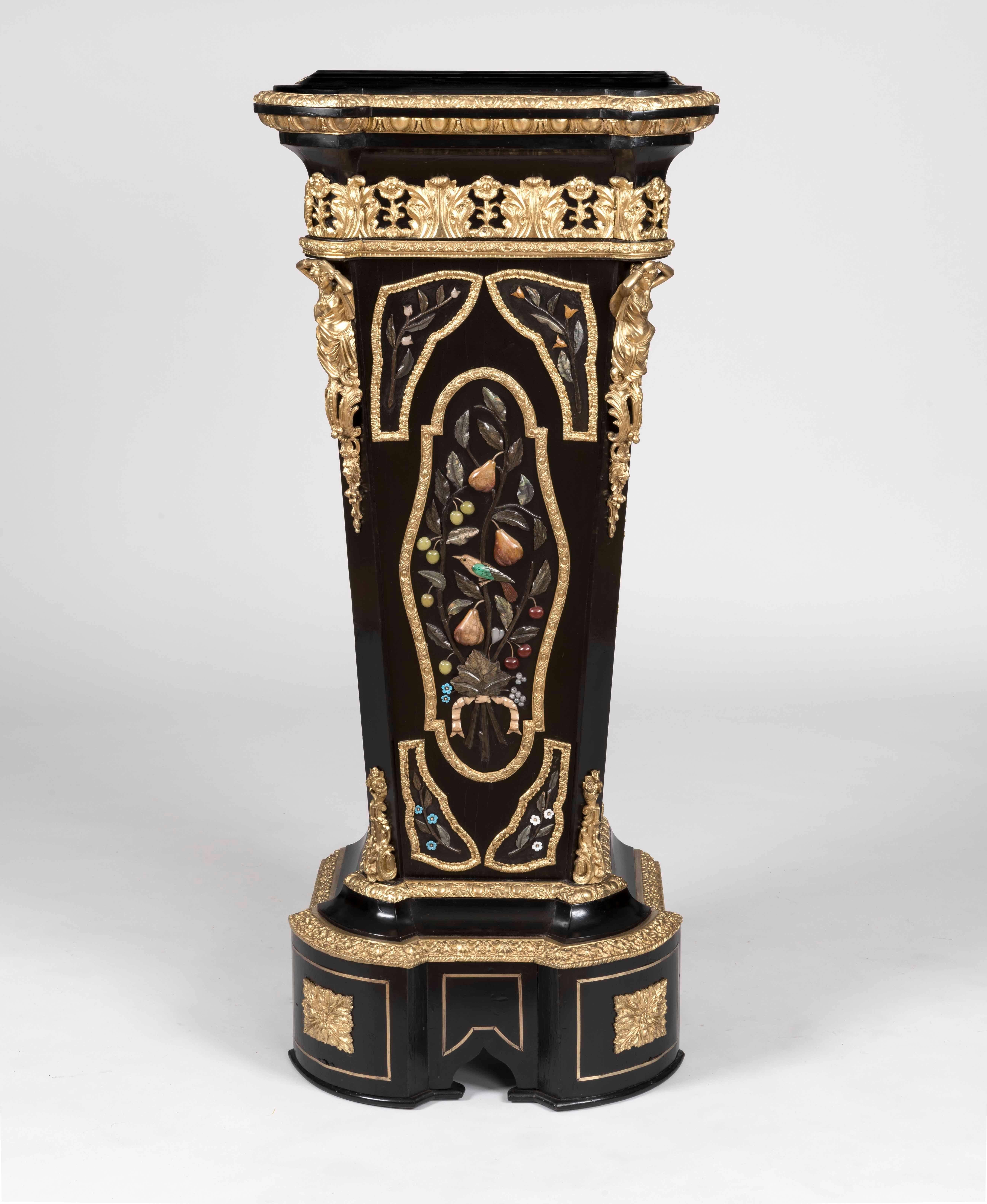 A pair of pedestals in the manner of Befort Fils of Paris

Constructed in bois noirci, dressed with gilt bronzes, and hardstone inlays; rising from incurved serpentine stepped bases, the inverted tapering columns having central hardstone panels