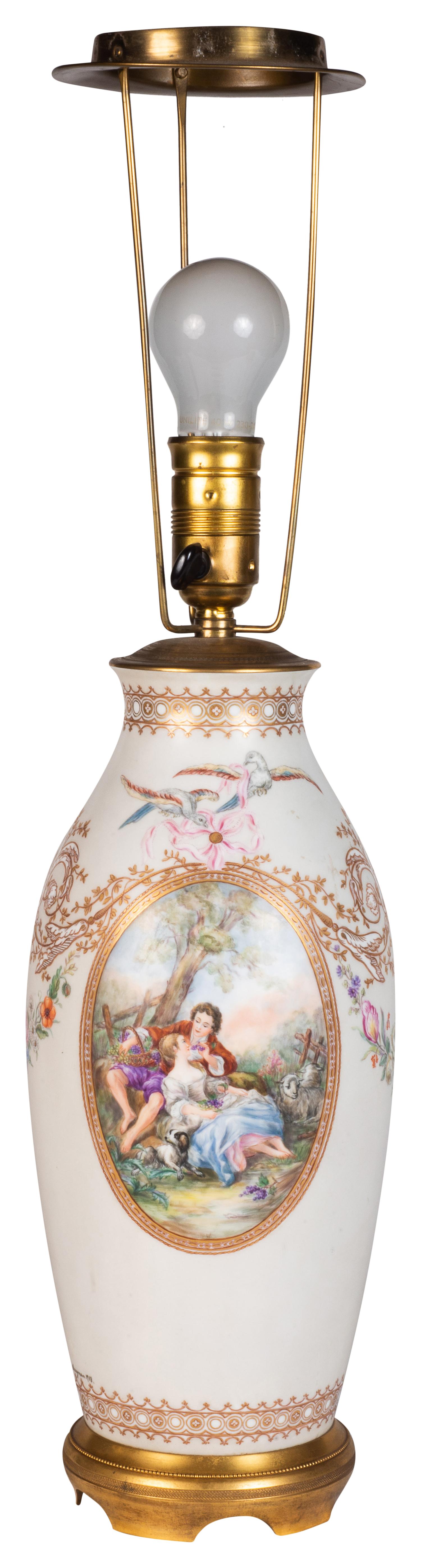 Vase / lampe en porcelaine de Paris peinte à la main, de belle qualité, datant de la fin du 19e siècle. Elle est ornée d'un magnifique décor doré en volutes, avec deux panneaux ovales représentant des scènes romantiques, le tout reposant sur une
