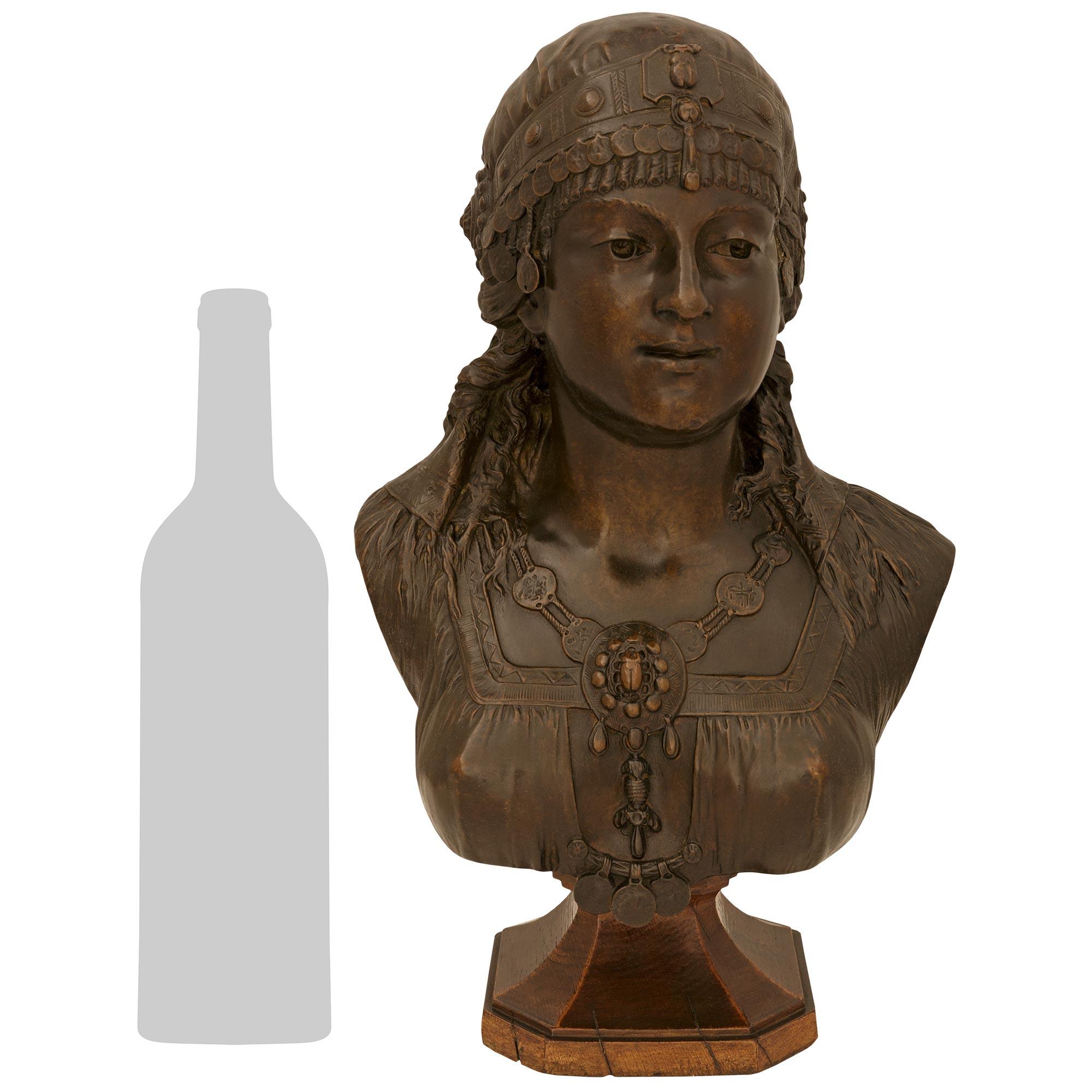 An elegant and high quality French 19th century patinated Bronze and Oak bust signed Cesar Ceribelli, Paris. This charming statue of a young Gypsy girl is raised on a square Oak base with cut corners and mottled edges. Above is the stunning bust of