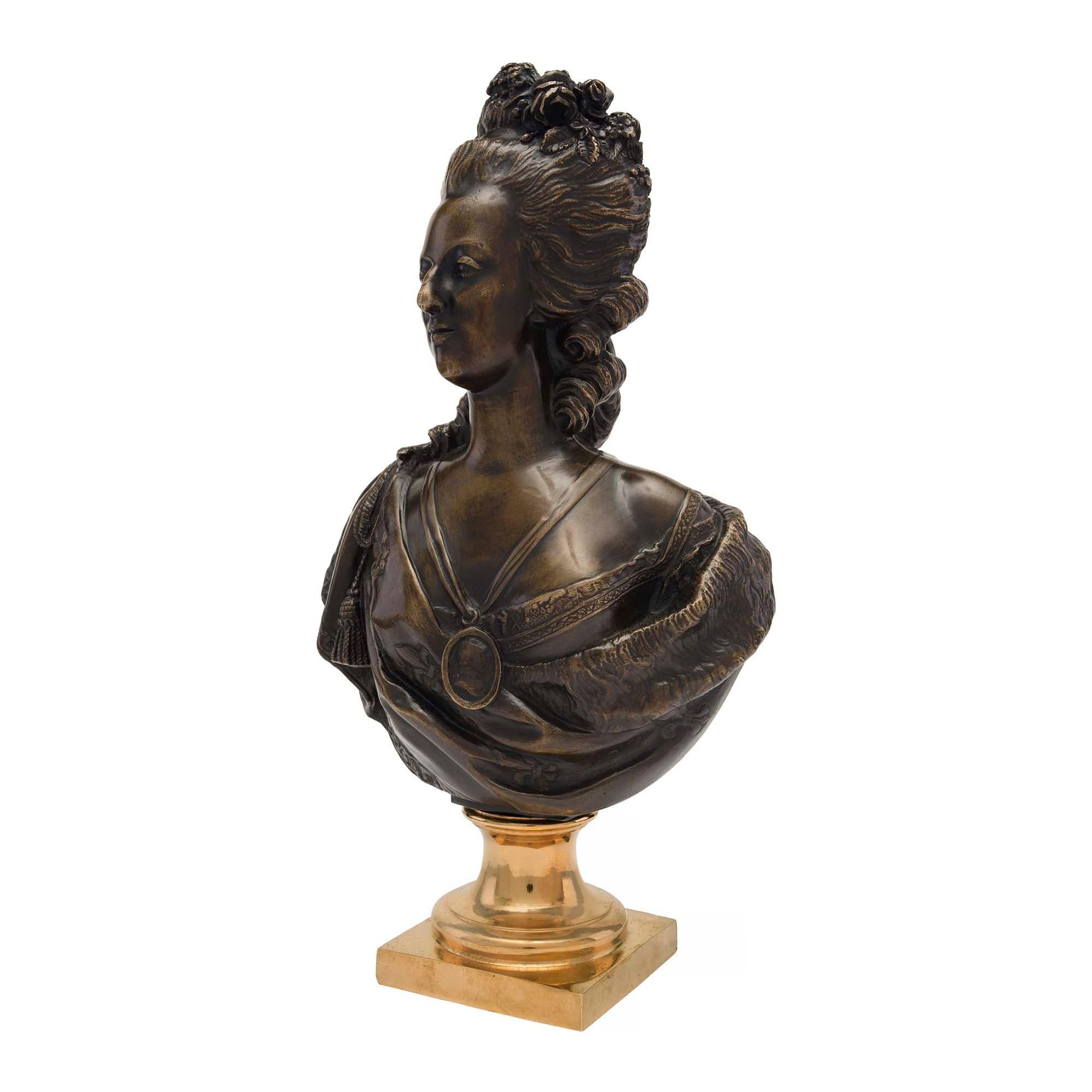 Magnifique buste de Marie-Antoinette en bronze patiné et bronze doré du XIXe siècle signé par Houdon. Le buste de grande qualité est surélevé par une base carrée en bronze doré et un piédestal à socle moucheté. Le buste en bronze patiné richement