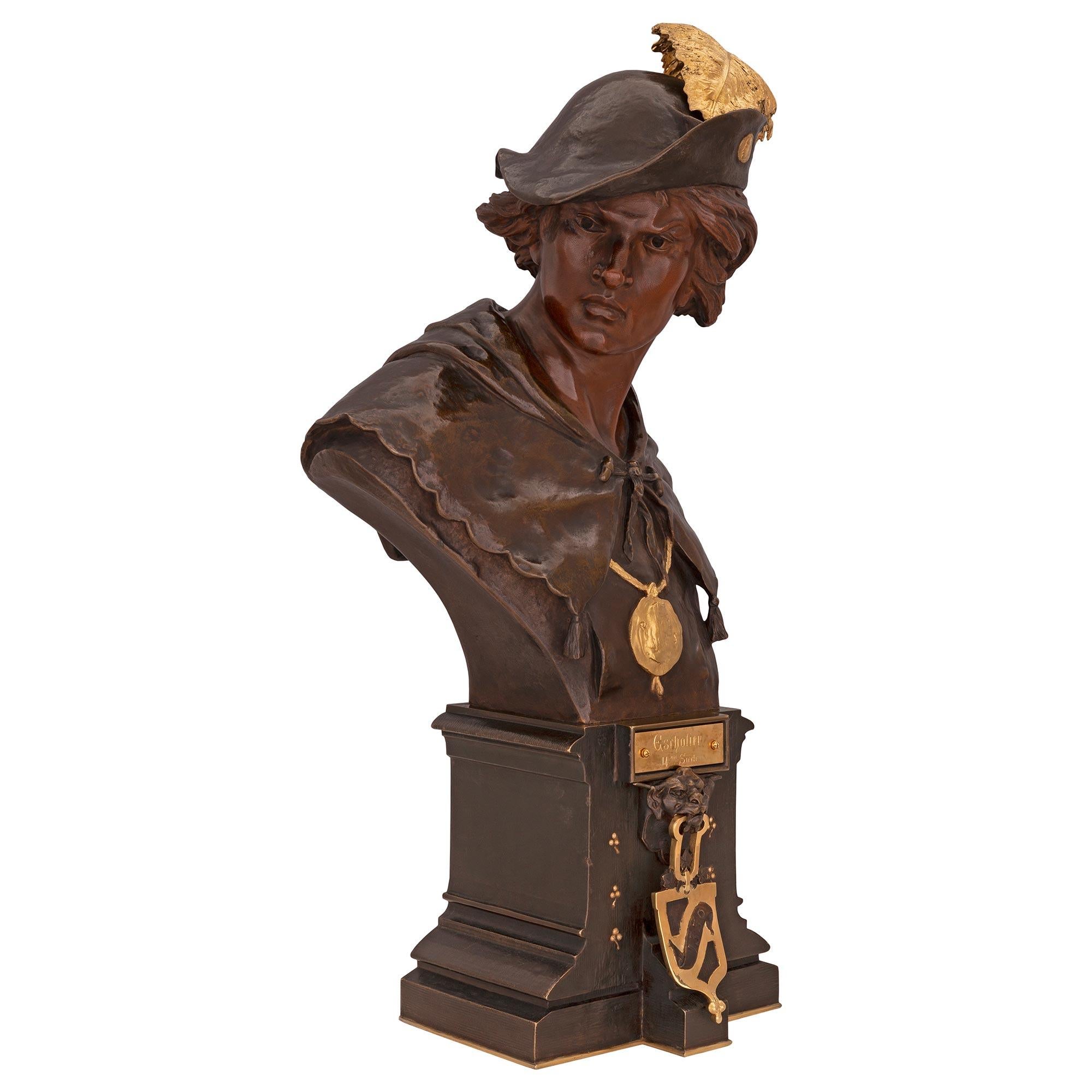 Un beau buste en bronze patiné et en bronze doré du 19ème siècle, intitulé ESRHOLIER et signé par EMILE LOUIS PICAULT. Le buste est surmonté d'une base carrée dotée d'un fin filet inférieur en bronze doré et d'un ravissant motif tacheté. Sur le