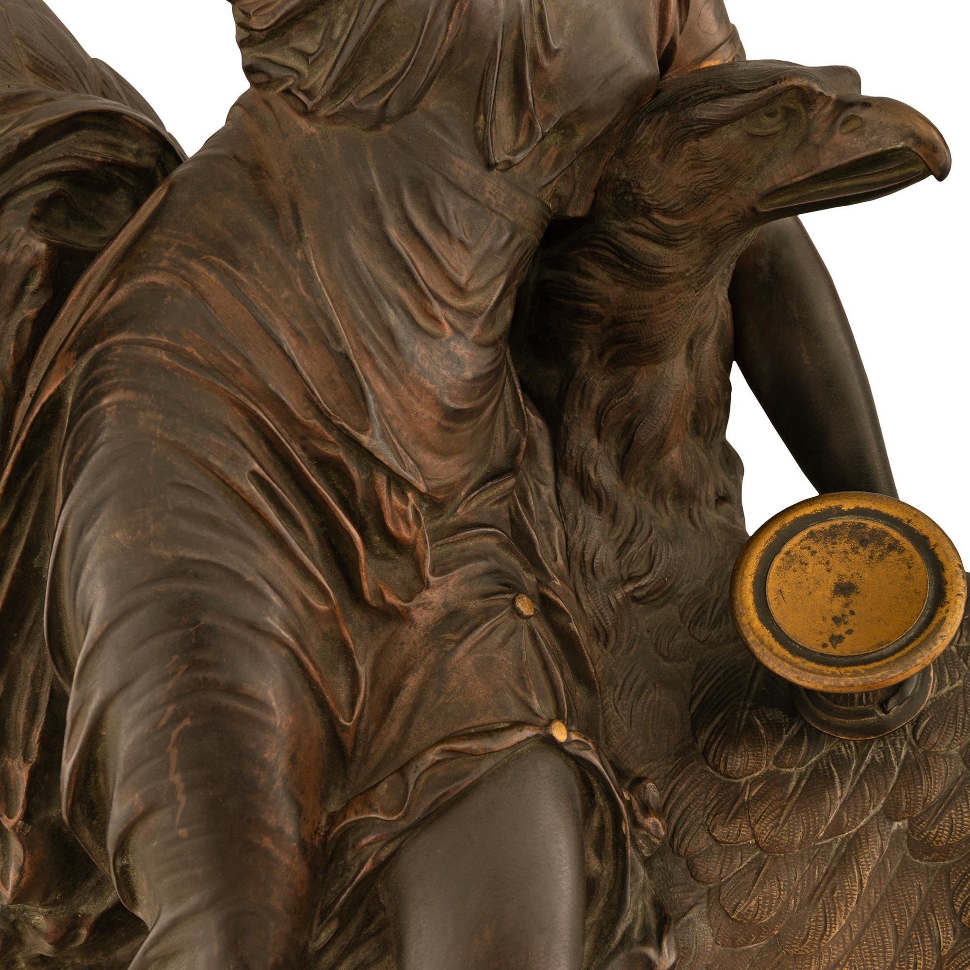 A stunning French 19th century patinated bronze statue of Hebe and the Eagle of Jupiter, signed by Louis Charles Hippolyte Buhot. The statue is raised by a circular black Belium marble base with a finely chased ormolu band depicting youthful cherubs