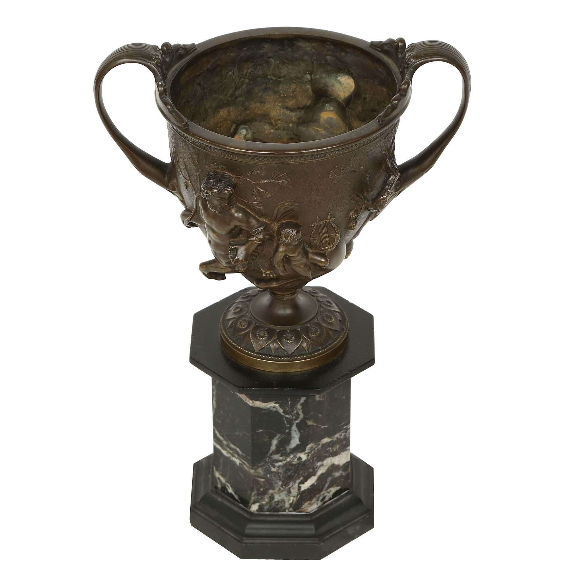 An extremely fine French 19th century patinated bronze tazza which is raised by an impressive octagonal shaped black Belgian marble base. Above the base is a circular support with a water leaf design. The tazza is flanked by large handles while both