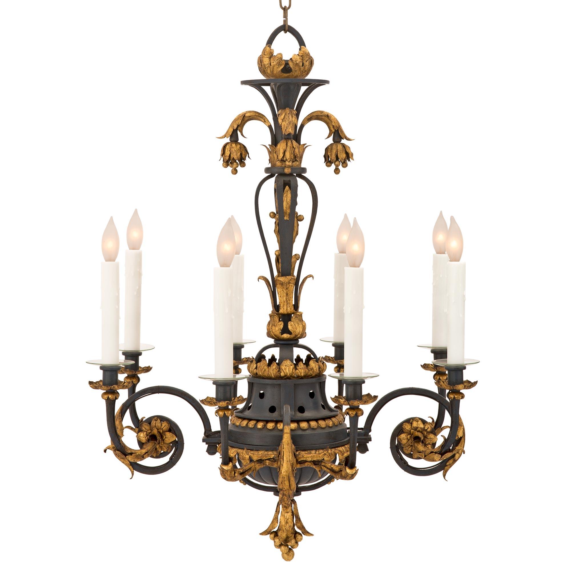 A beautiful and most decorative Country French 19th century patinated dark blue wrought iron and gilt metal chandelier. The eight-arm chandelier is centered by a beautiful charming berried and foliate bottom finial below the elegant reeded body.