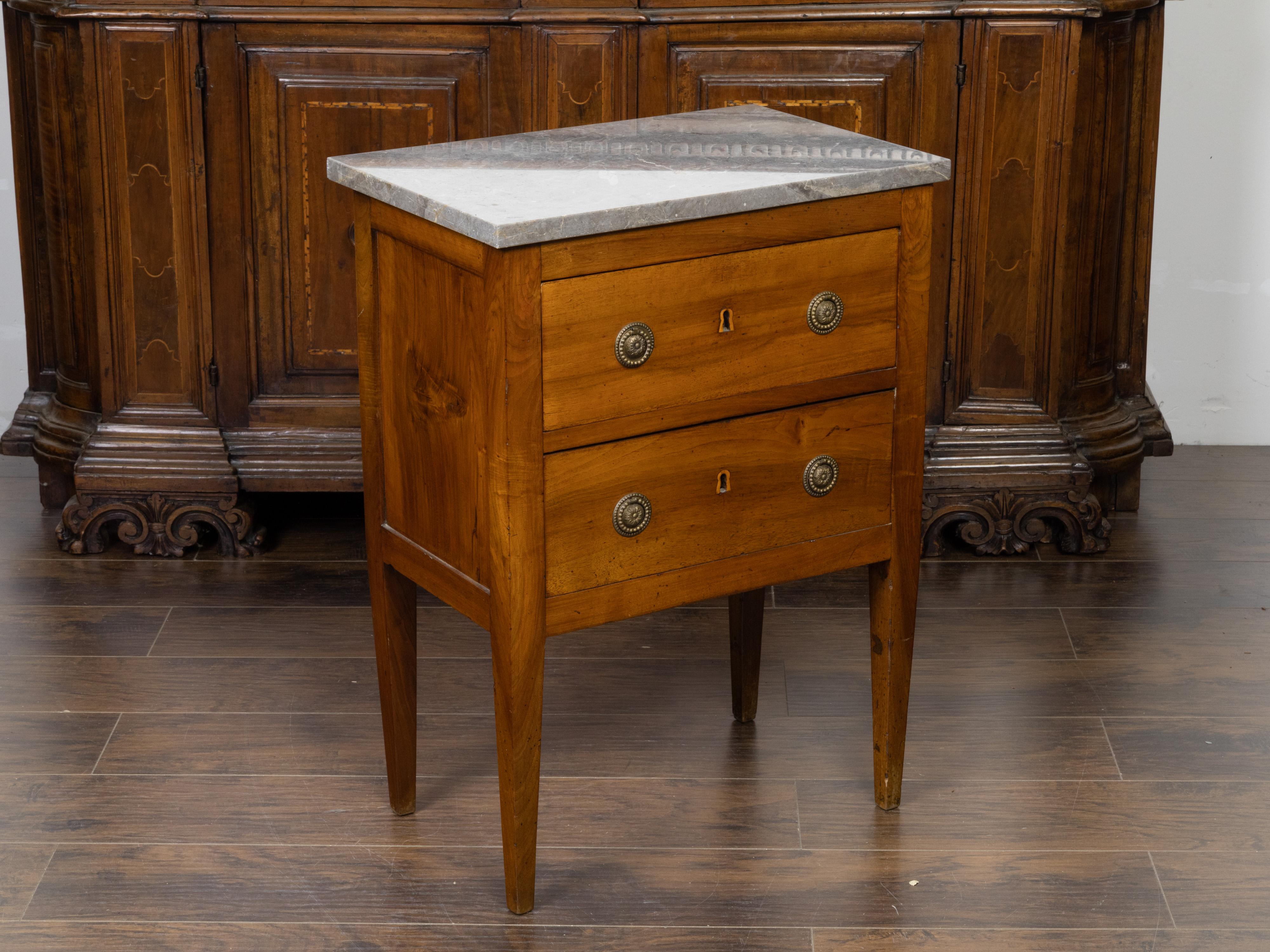 A petite French commode from the 19th century, with grey marble top and two drawers. Created in France during the 19th century, this petite commode features a rectangular grey marble top sitting above two drawers fitted with Classical hardware.
