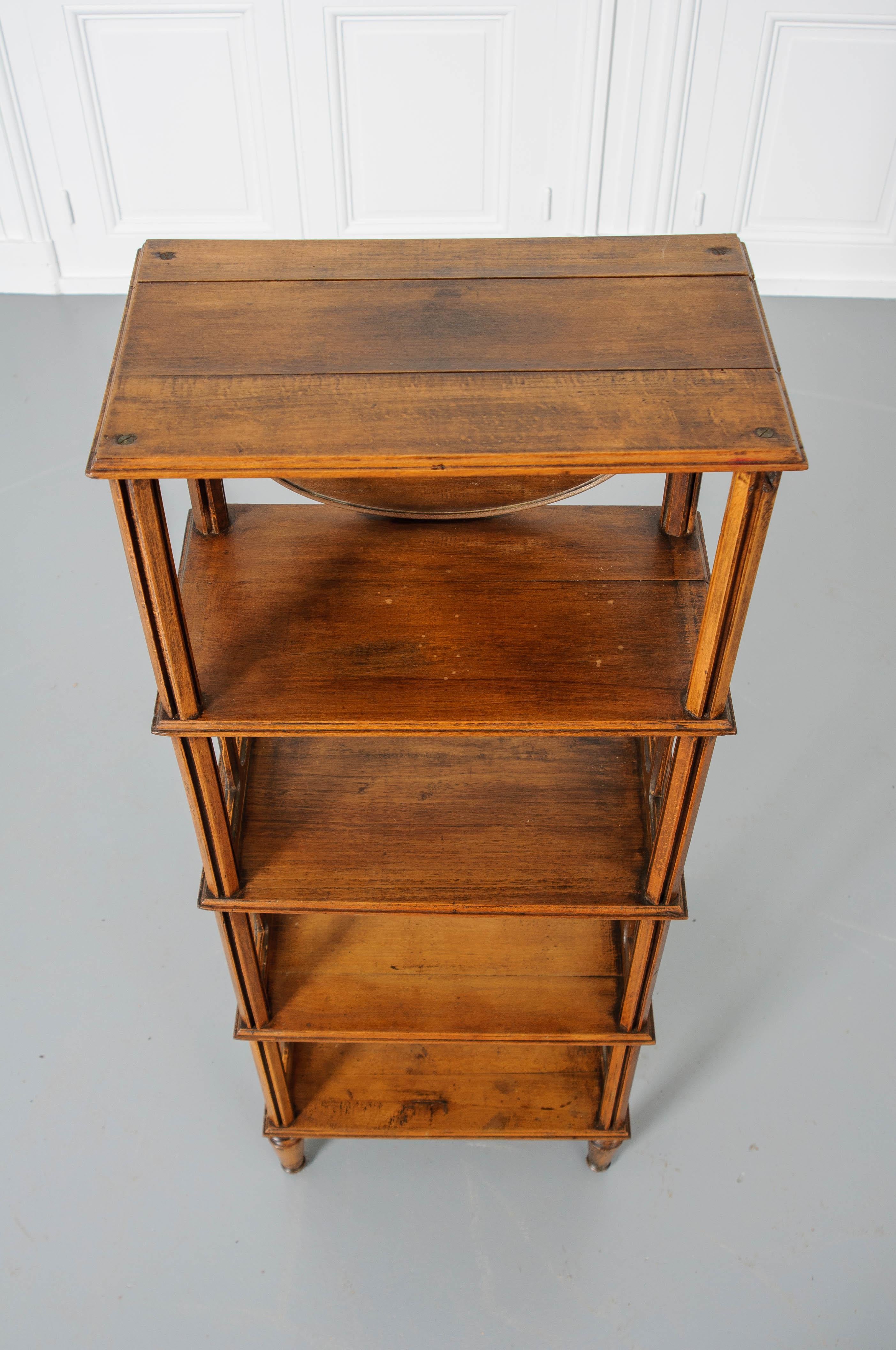 A petite but stylish French 19th century five-tier fruitwood étagère. This piece has five shelves that are spaced by unique supports. The lower three sections have panels with window-like openings on both sides. The top section has an oval mirror.