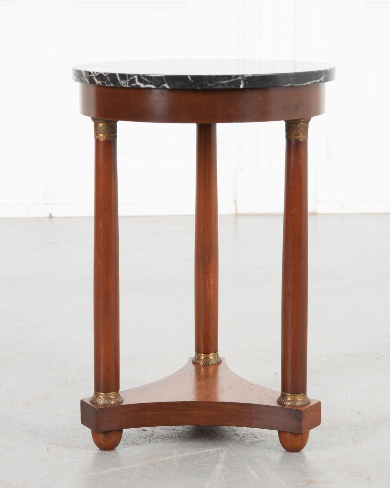 This darling petite 19th century Empire gueridon is the perfect addition to any home decor style! Beautiful black marble in great condition tops the rich mahogany base. Three turned column-like supports, each with highly decorative gilded ormolu