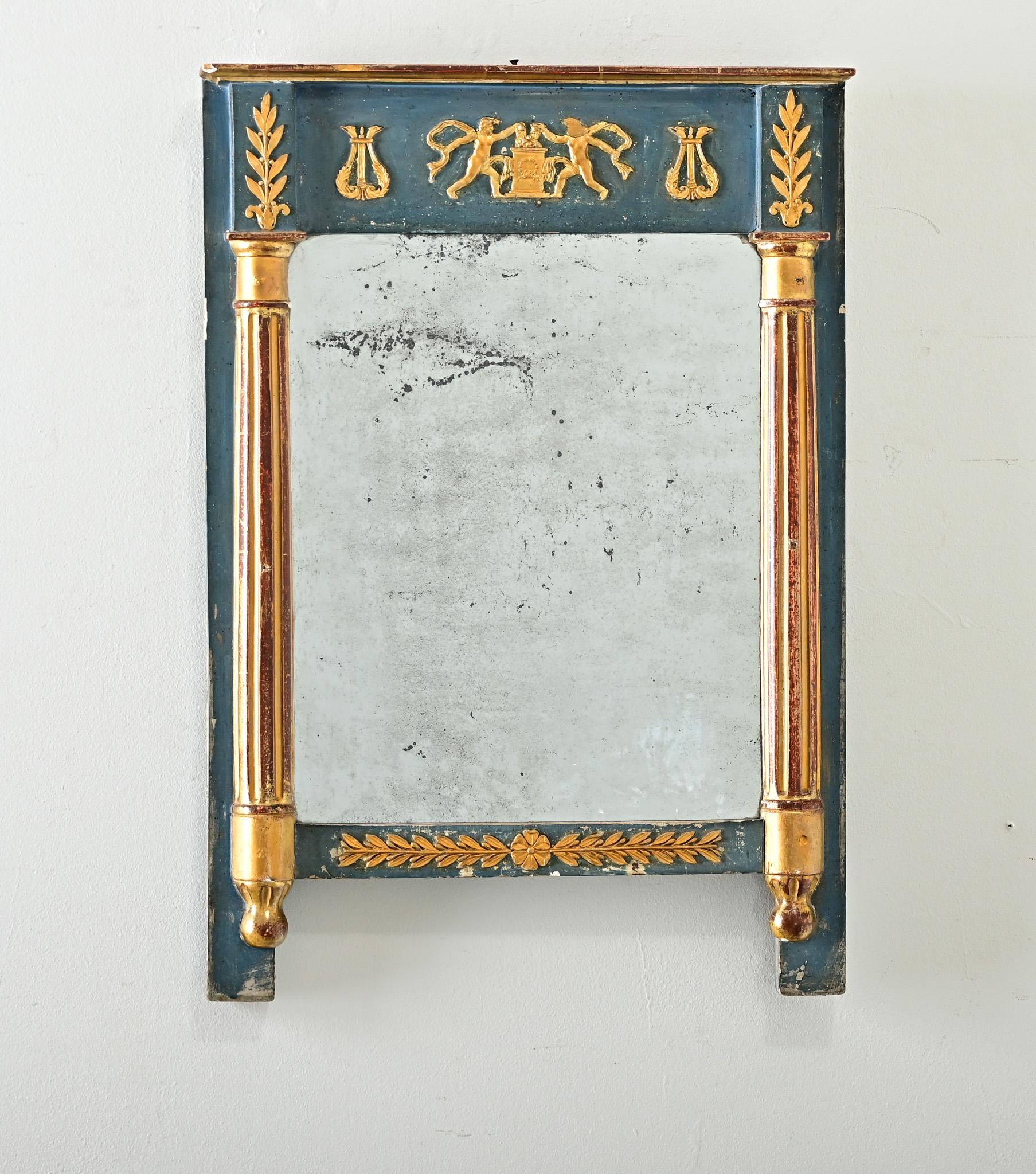 Favoloso specchio trumeau di ispirazione neoclassica proveniente dalla Francia del XIX secolo con motivi stilizzati in pacchi dorati. Al centro del fregio ci sono due figure dorate, simili a cherubini, che indossano solo fasce di tessuto