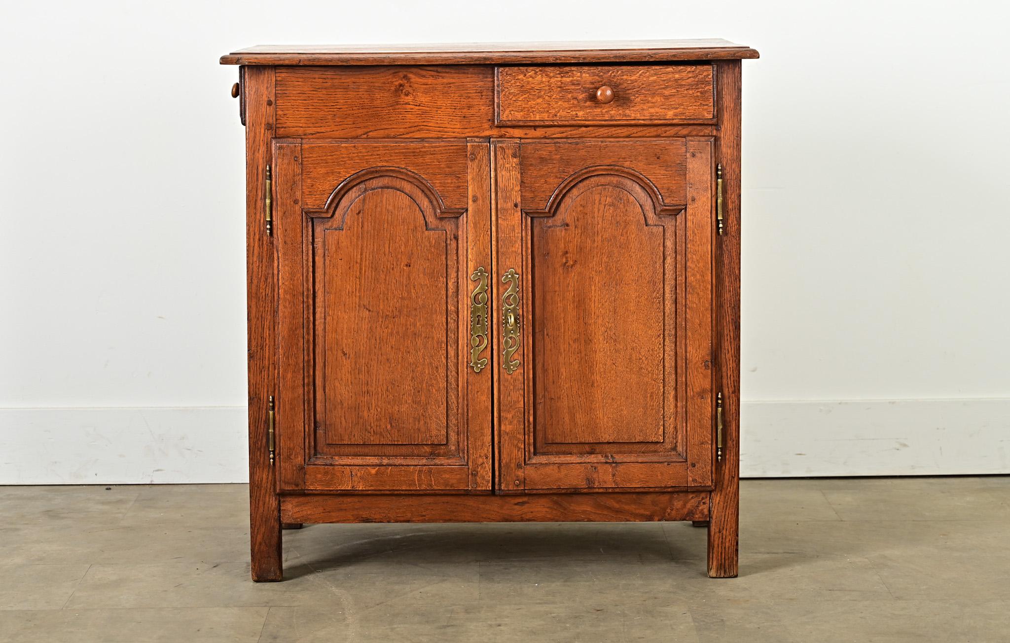 Un affascinante petite buffet in legno massiccio di quercia del XIX secolo, che esibisce un fascino e una creatività da provincia francese che conferisce personalità al compatto mobile contenitore. Il semplice piano a listoni risplende dei toni