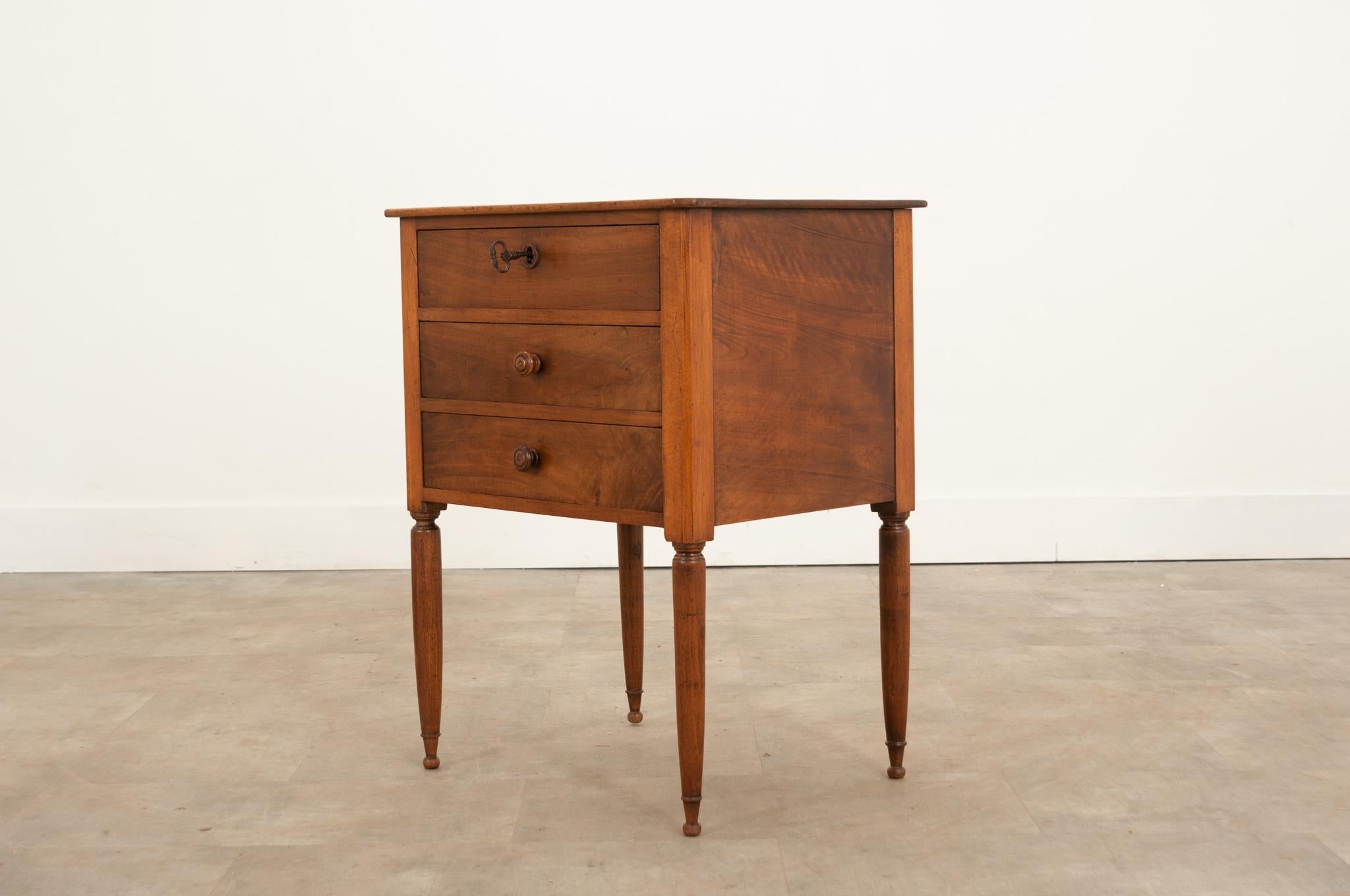 This darling commode was crafted from a richly toned walnut during the 1880s in France. The whole has been recently cleaned and waxed with French wax paste and showcases a fine patina. A bank of three drawers compose the petite body. The top drawer
