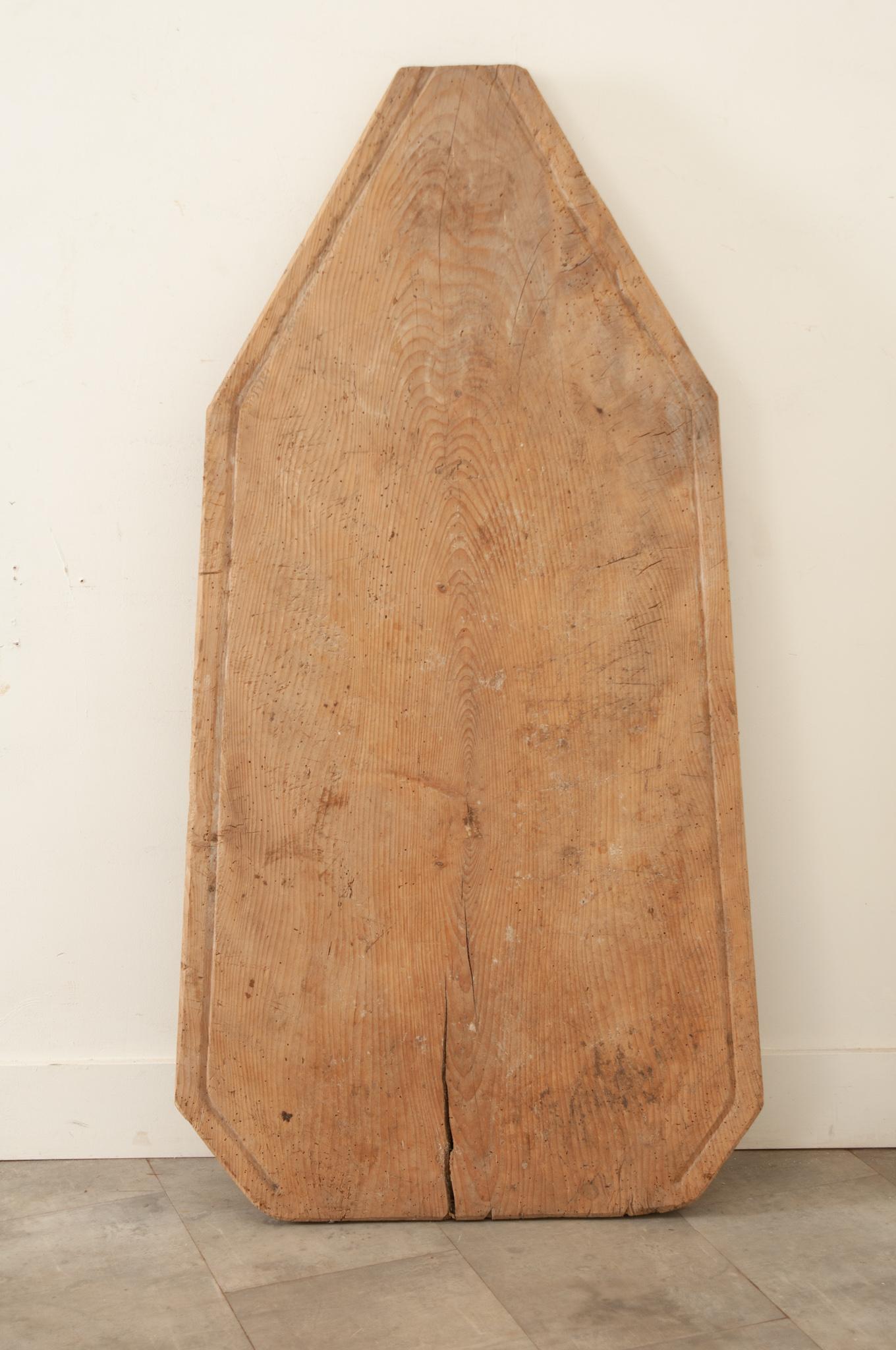 A large early 19th century French cheese draining board, hand-crafted in France circa 1820. This solid pine board with a shallow rim along the edges was used to drain the whey from cheeses as they were processed. Featuring scrapes and markings from