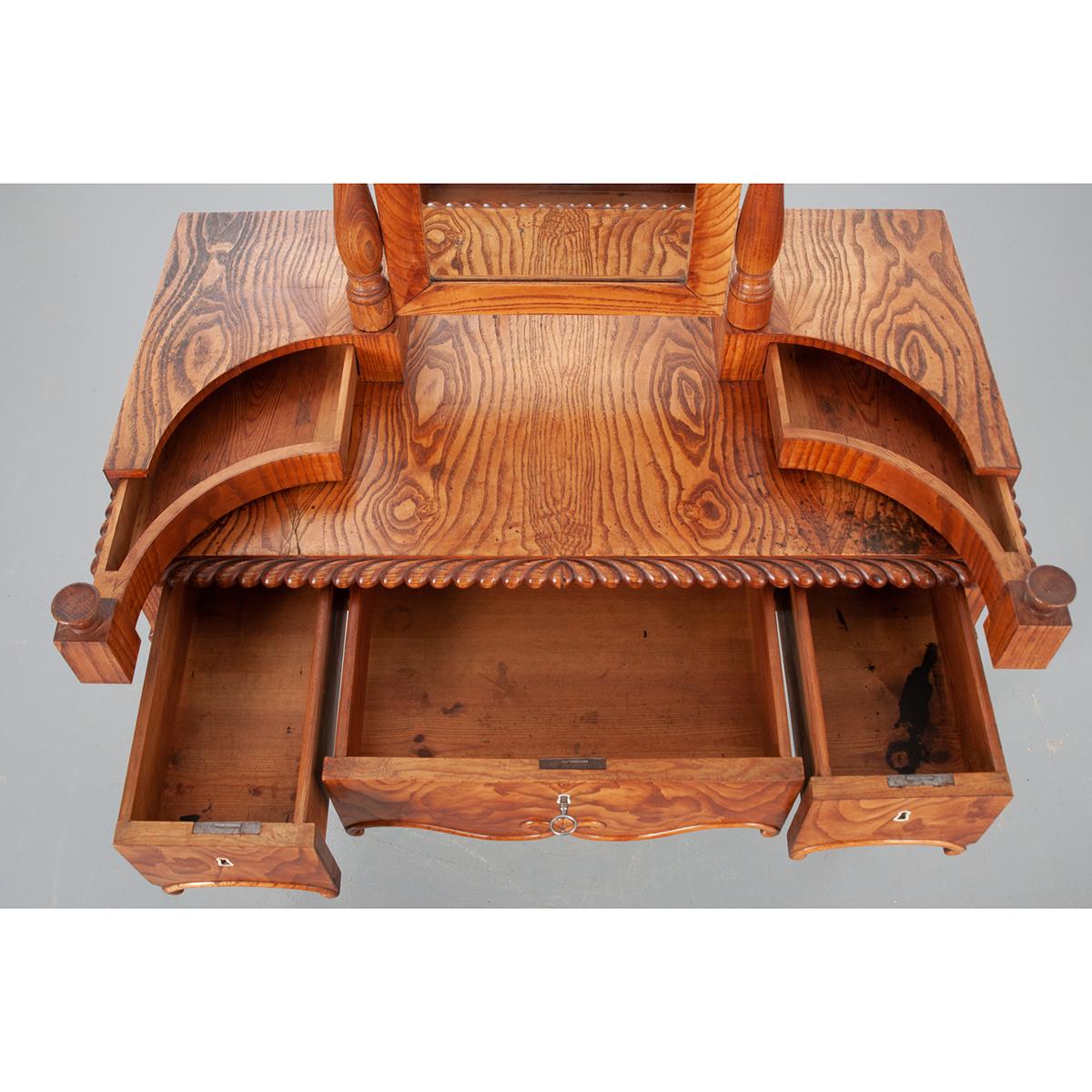This pine dressing table has bold wood grain and is ideal to start your vanity routine. The surface is at 30-?” H with a pivoting mirror and five drawers. The mirror is 20-?” H x 13-?” W x ¾” D and is held between two turned posts. There are two,