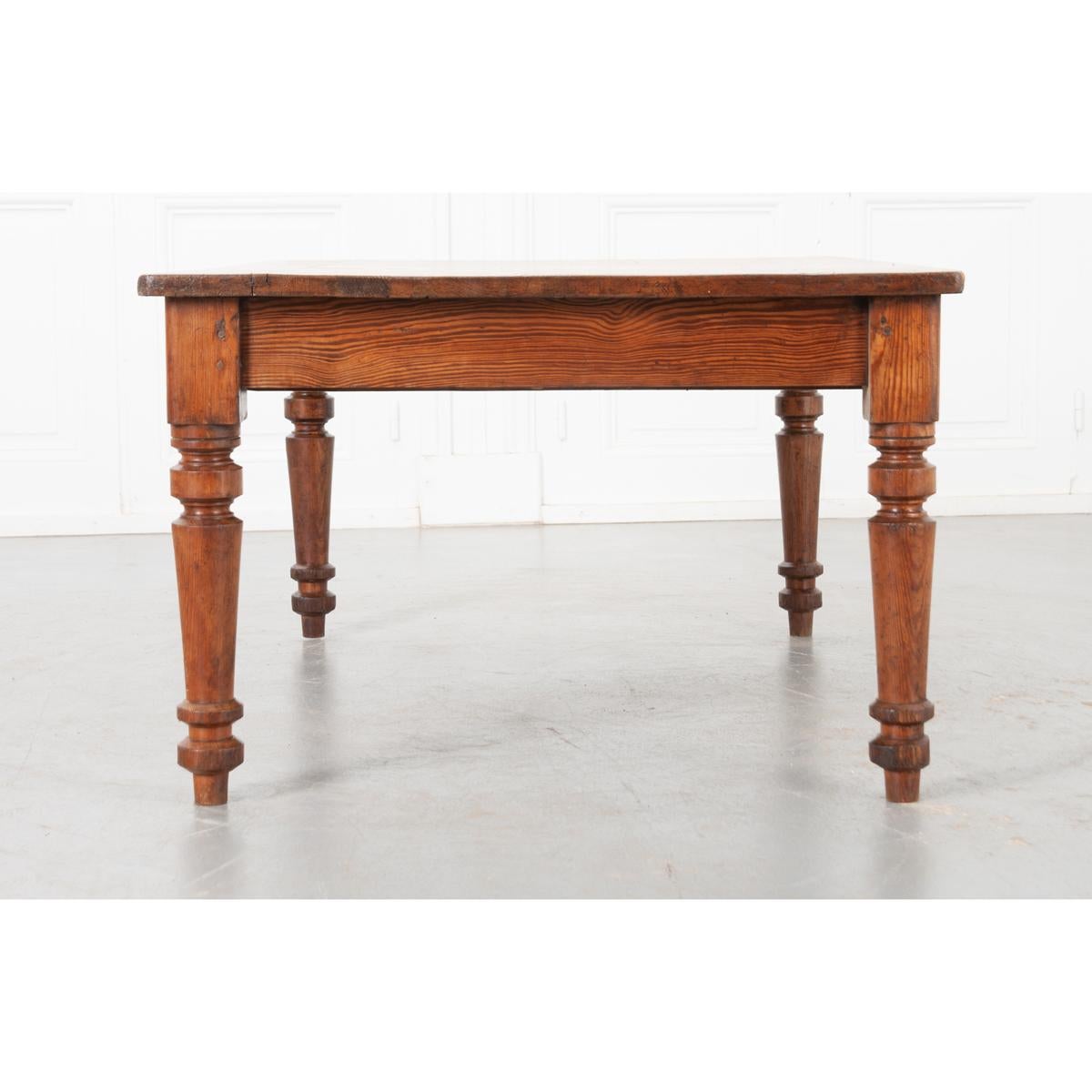This fine coffee table from the 1800’s is made from pitch pine, the stronger and generally thicker cousin of pine. Its dark and resinous grain lines contrast the bright honey color of the wood for a striking combination. The top, smoothed with