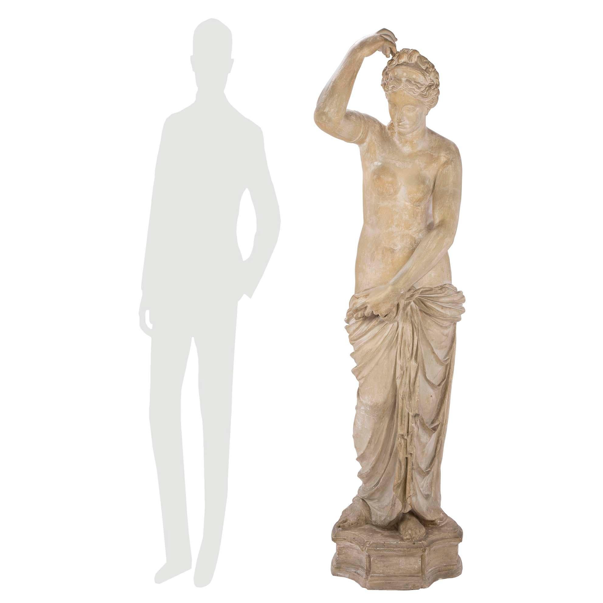 Eine schöne französische neoklassizistische Gipsstatue eines Mädchens aus dem 19. Die Statue steht auf einer gesprenkelten Plattform mit konkaven Stirnseiten. Das Mädchen ist in klassischer Weise um die Hüften drapiert. Eine Hand hält ihr Gewand