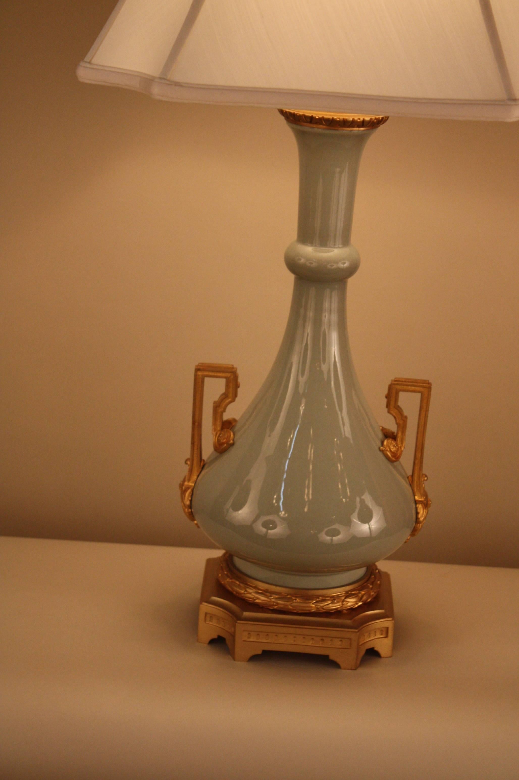 Elegant 19th century soft celadon color electrified porcelain oil lamp with fantastic bronze base and hard ware by famous Parisian lighting co of Gagneau & Co.