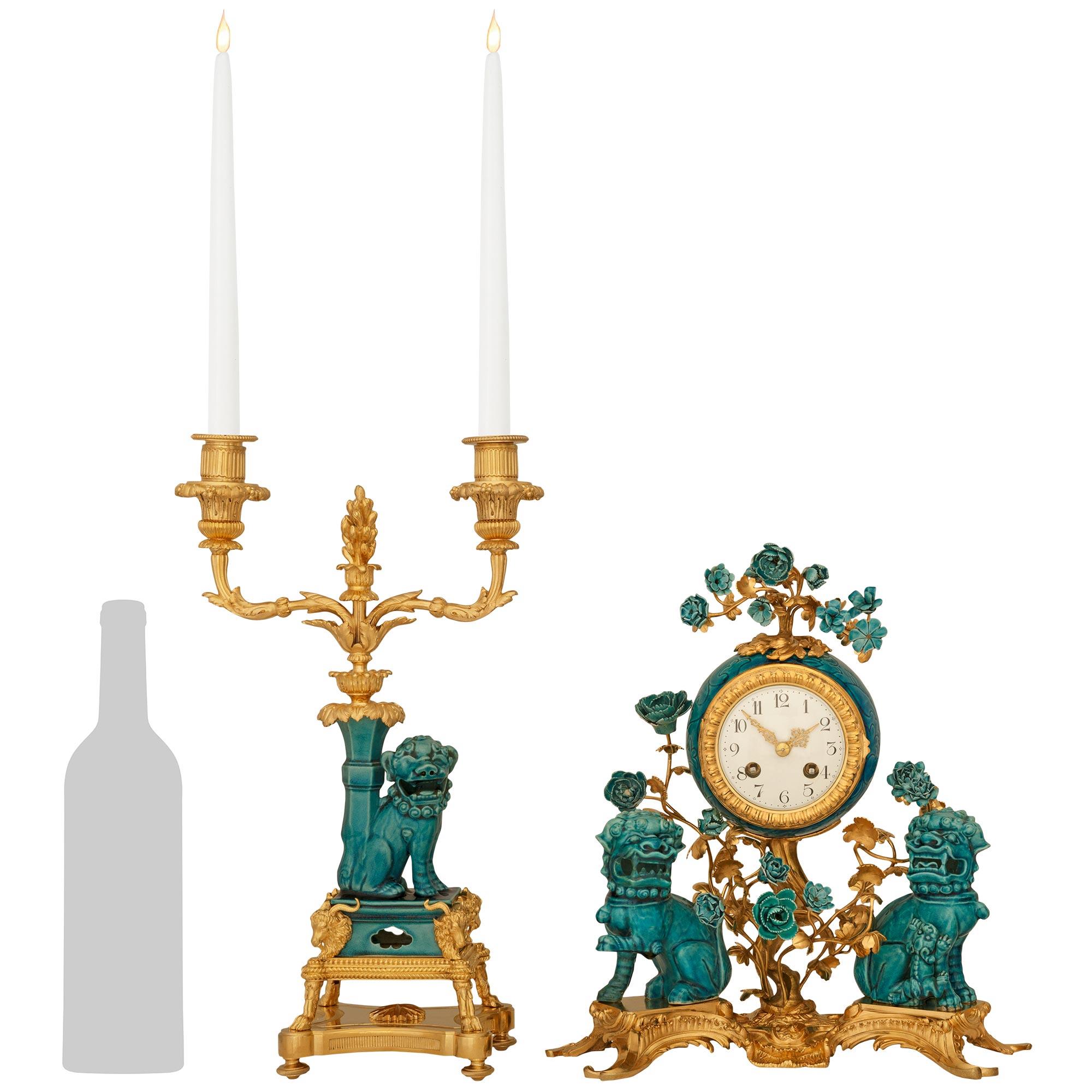A high quality and most decorative Chinese Export Porcelain and French 19th century Ormolu mounted garniture set, stamped S.F.R.A. This stunning three piece garniture set consist of a central clock and two candelabras, with the clock being raised on