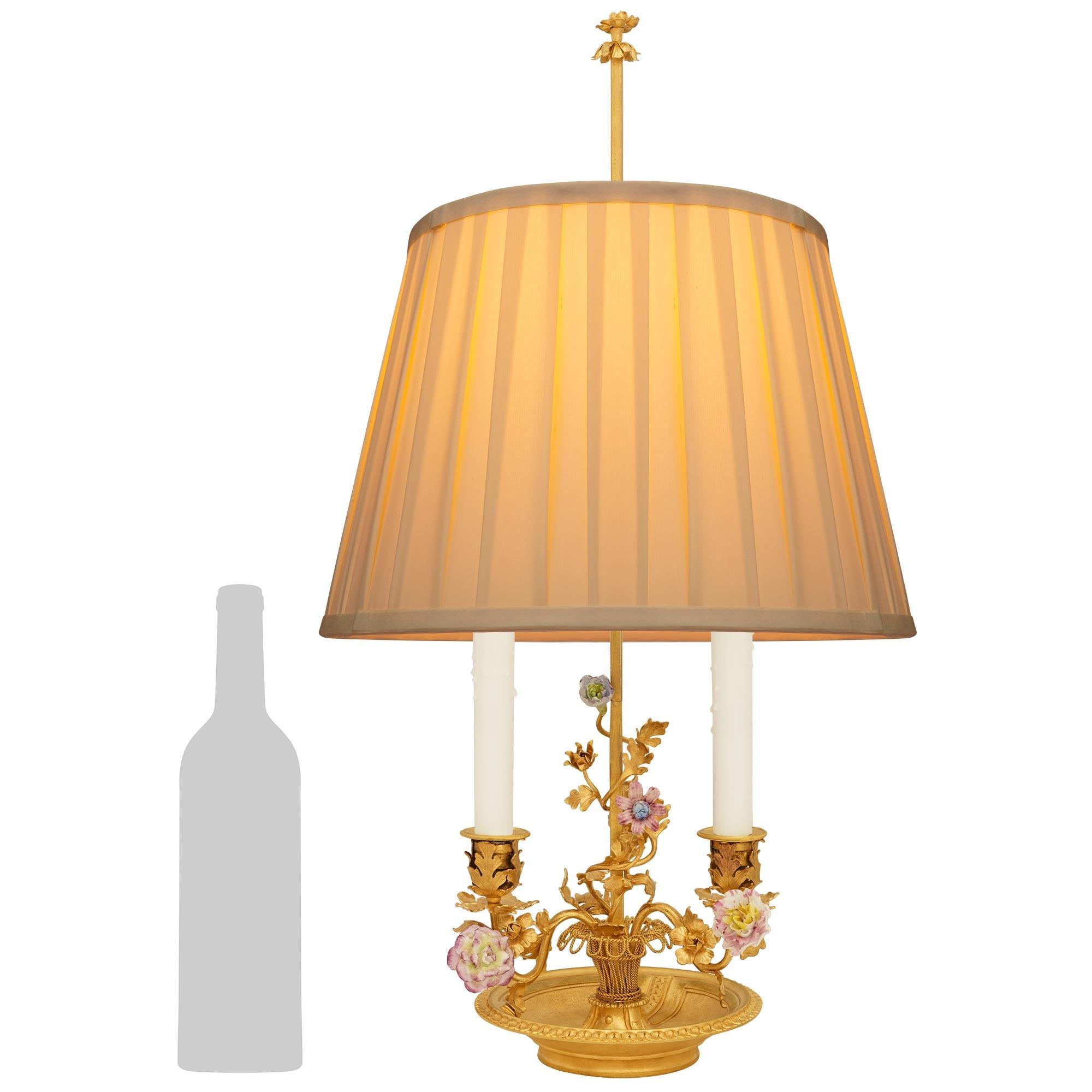 Preciosa lámpara Bouillotte de porcelana sajona, metal dorado y ormolu del siglo XIX, francesa y de gran calidad, de estilo Luis XVI. Esta encantadora lámpara candelabro electrificada se eleva sobre un zócalo de Ormolu que sostiene un platillo