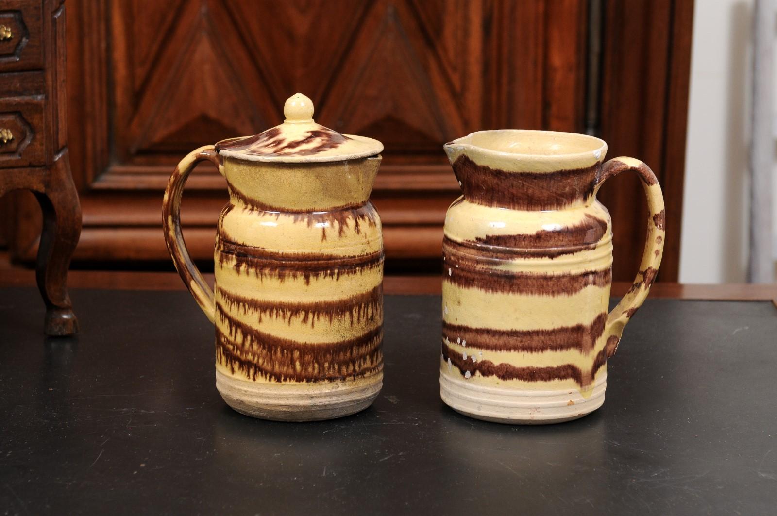 Two French pottery pitchers from the 19th century with cream and brown glaze, priced and sold individually $395 each. Created in France during the 19th century, these pitchers feature a cream ground beautifully contrasted by a brown glaze applied