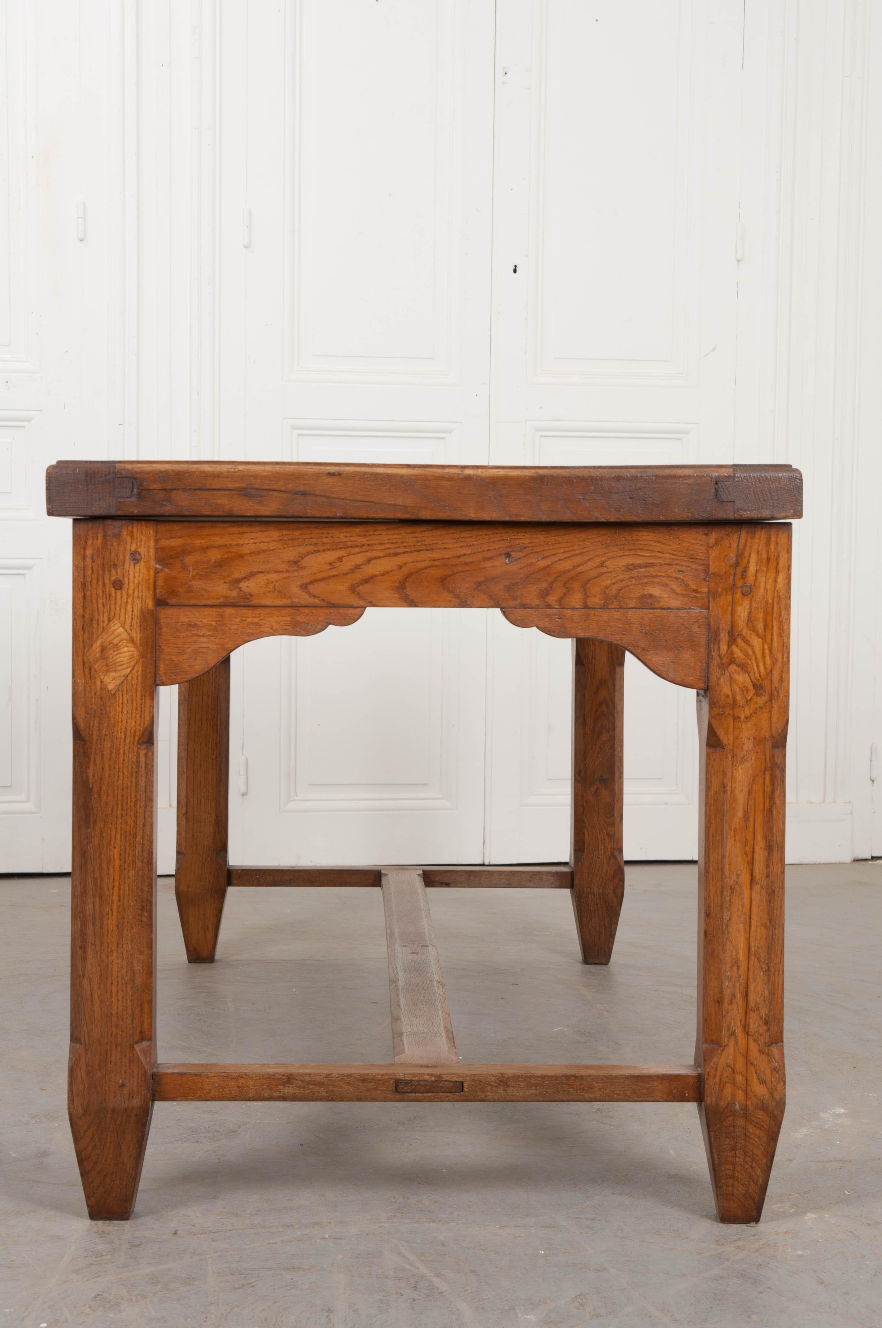 This unique and substantial oak refectory table, circa 1870s, was found in the French countryside. Of doweled and mortise-and-tenon construction, it features a triple-sectioned top of five horizontal planks separated by two vertical planks over