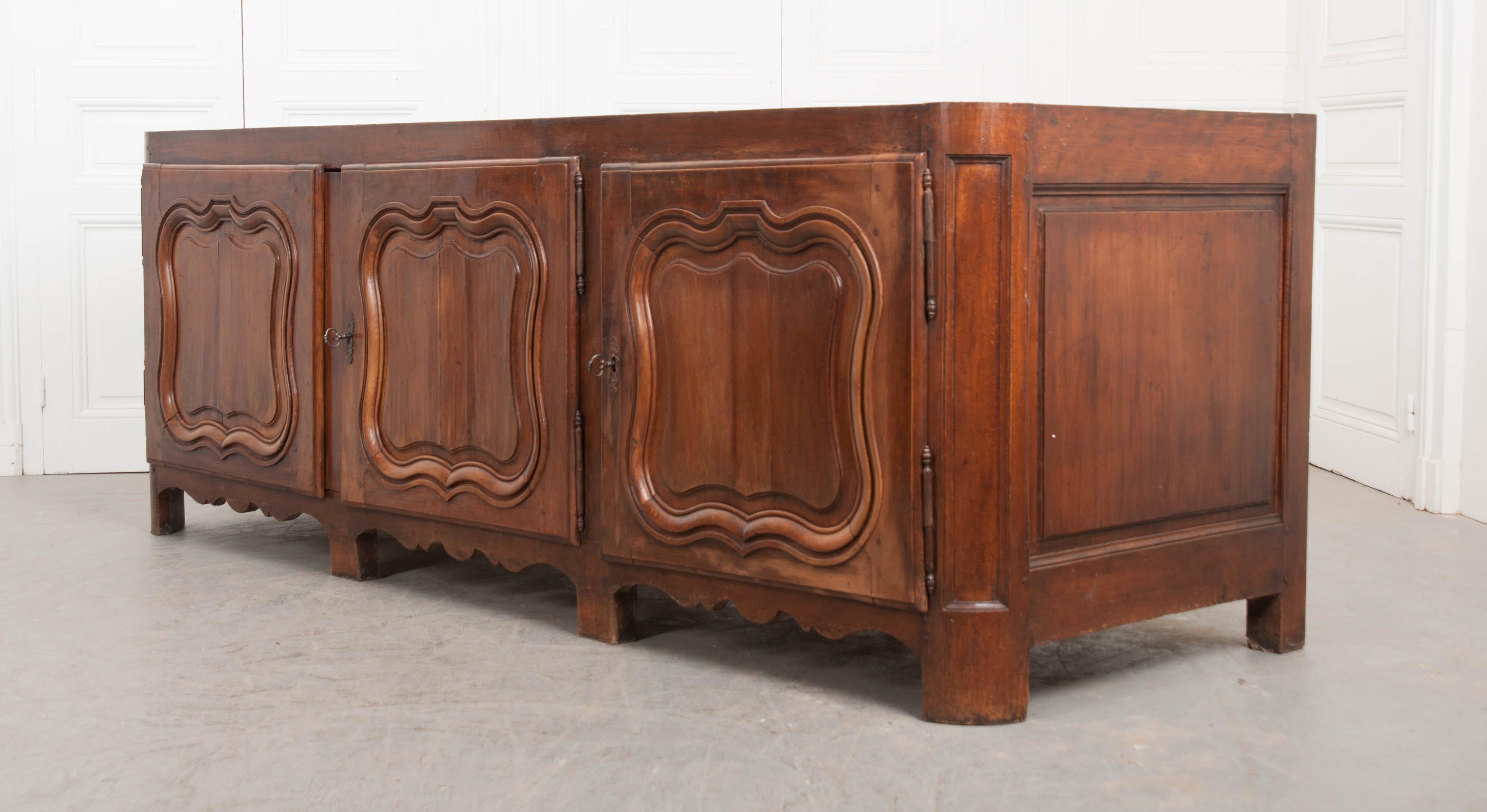 This remarkable French Provincial Louis XV style walnut and marble-top enfilade, circa 1840, is quite deep, offering plenty of storage. The impressive grey-brown marble top, with white inclusions, has recently been repaired and shows some scratches.
