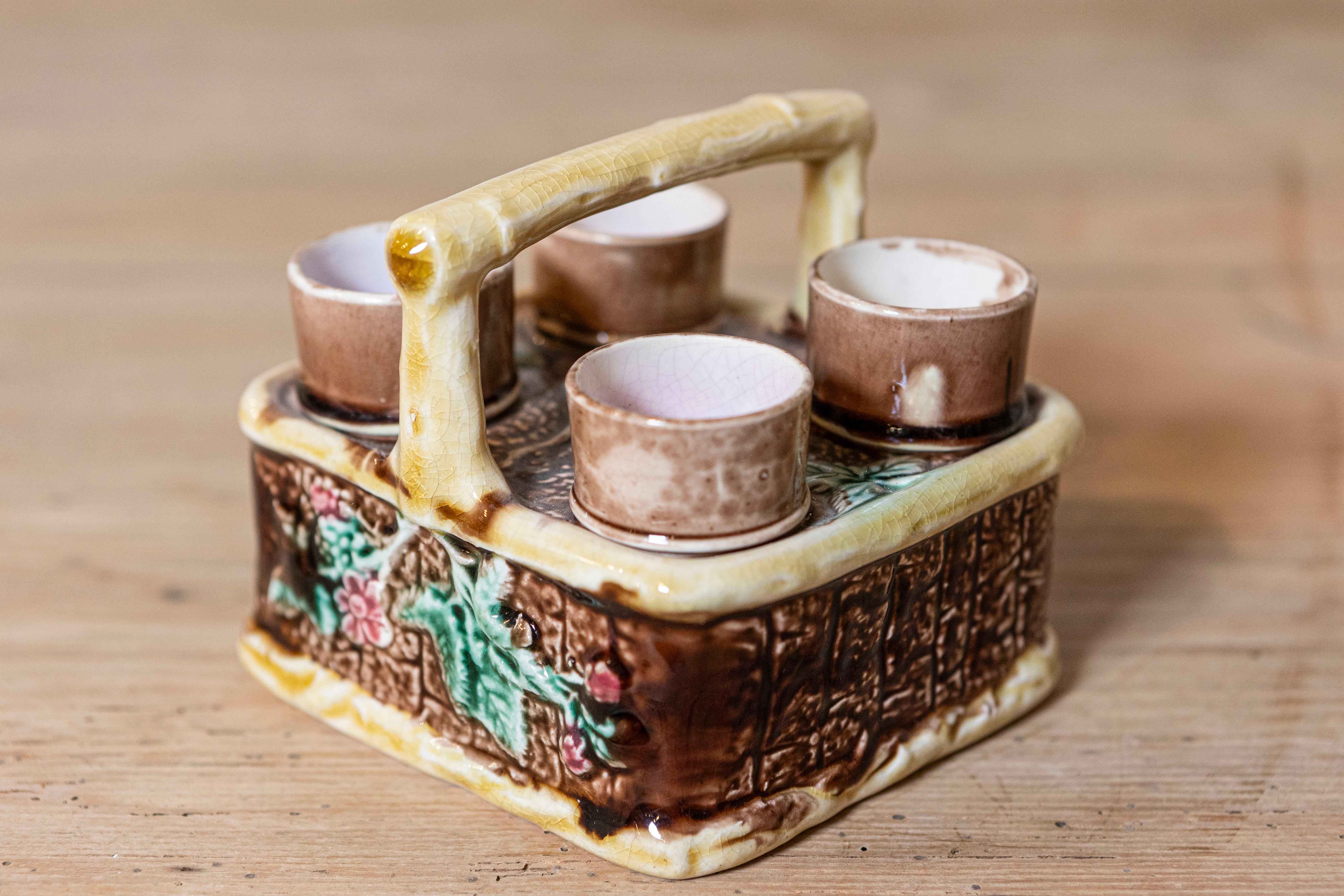 Juego de té francés del siglo XIX, con cesta y asa de mayólica adornadas con follaje. Creado en Francia durante el siglo XIX, este raro juego de té nos encanta por su inusual diseño. Cuatro tazas de té están encerradas en una cesta de mayólica